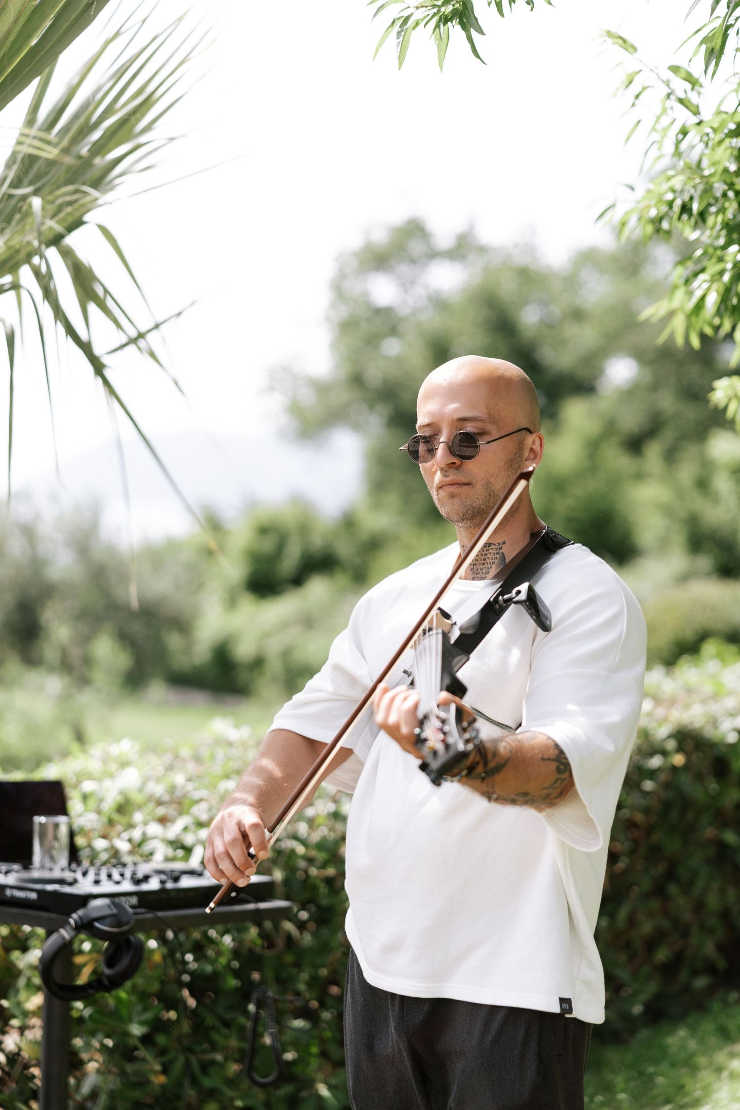A series of photos showing a musician in a white shirt playing the trombone outdoors in a garden setting.