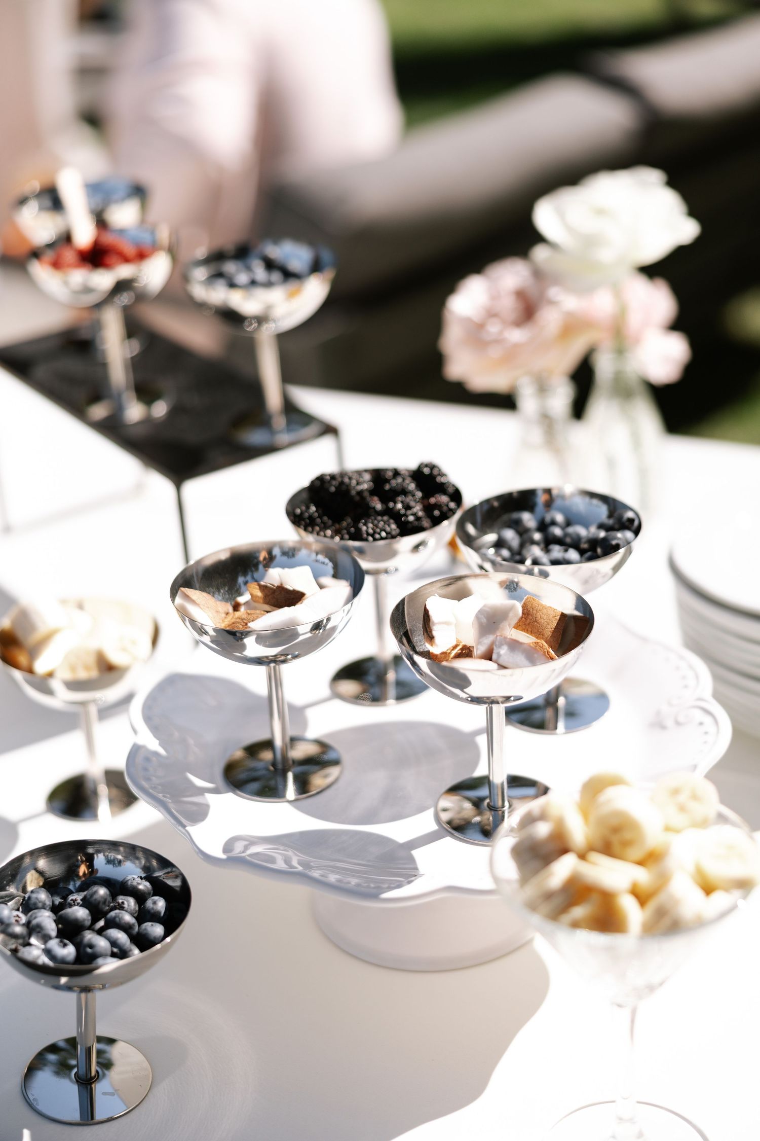 Elegant wedding reception table with martini glasses filled with blueberries and desserts.