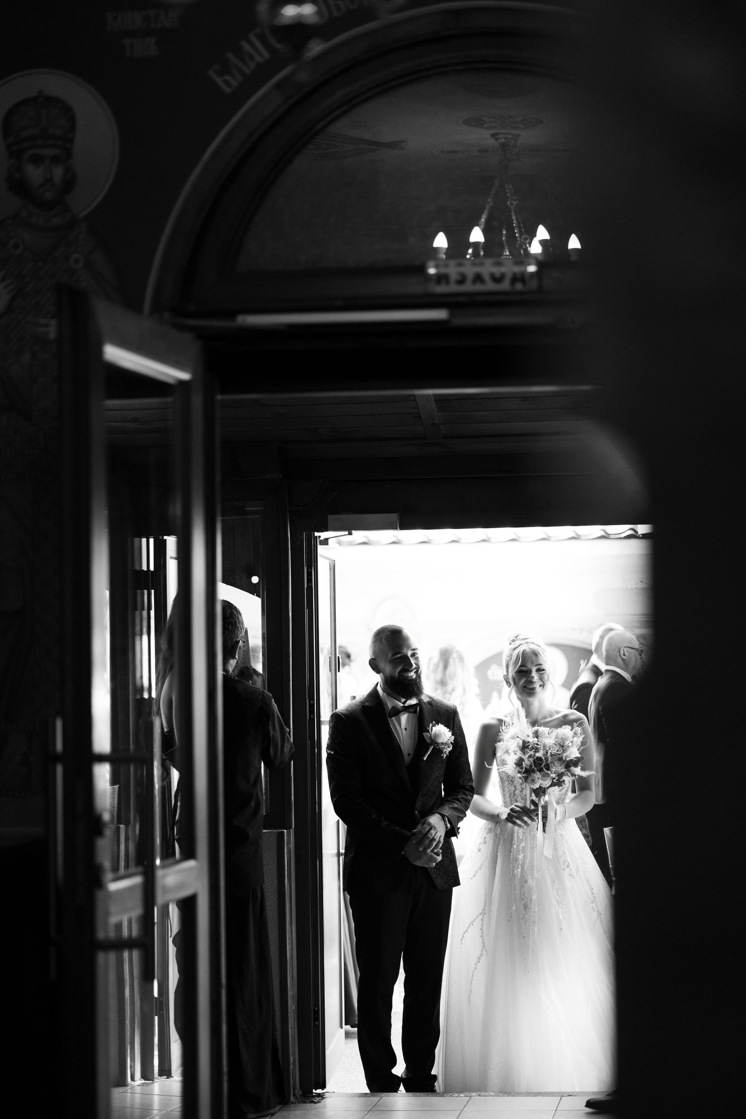 A silhouetted sequence of wedding moments showing a bride and guests in a dark hallway with dramatic lighting.