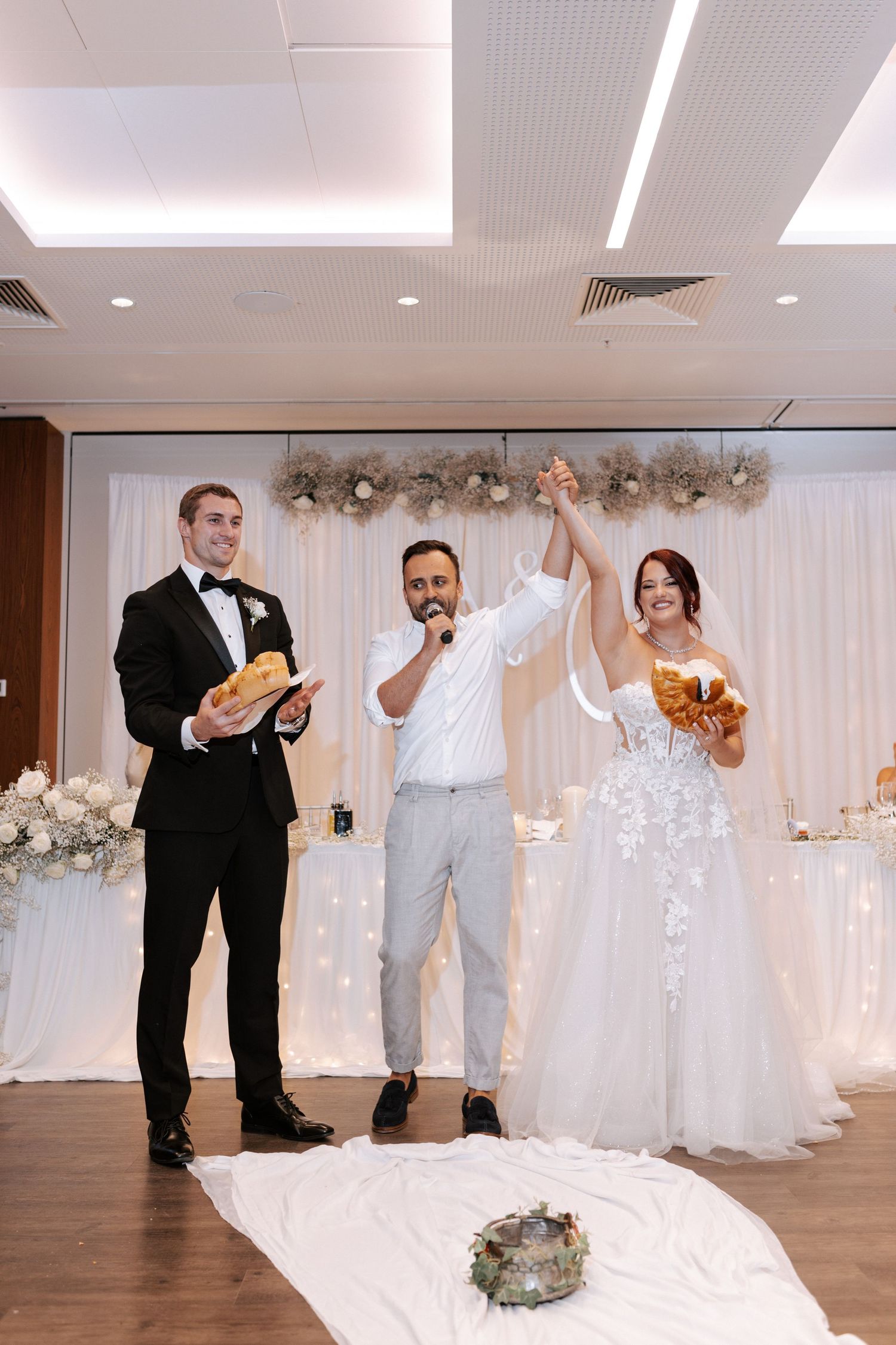 Wedding celebration with guests participating in a joyful ceremony moment with decorative backdrop.