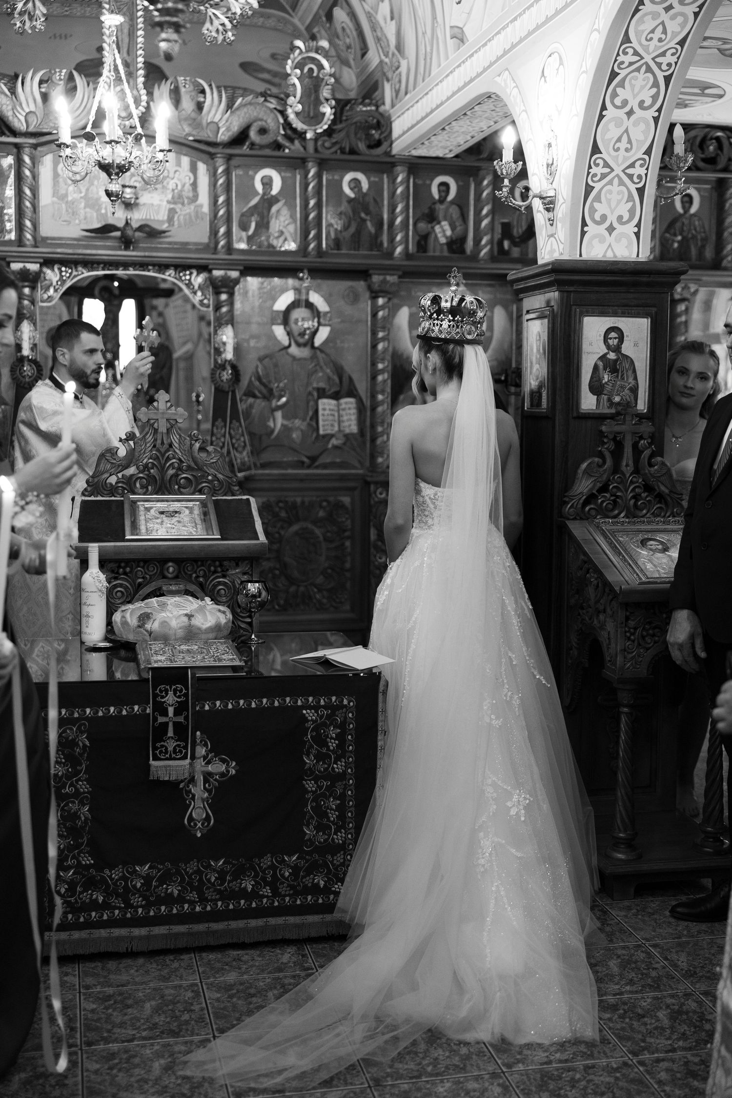 A traditional church wedding ceremony with bride in white gown standing at the altar amid ornate religious decor.