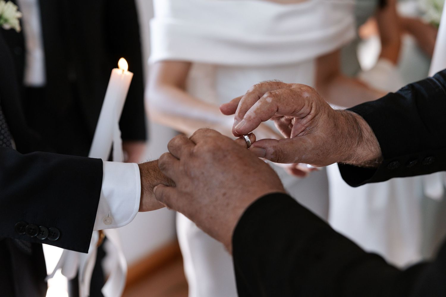 Close-up shots of hands exchanging wedding rings during a traditional ceremony.