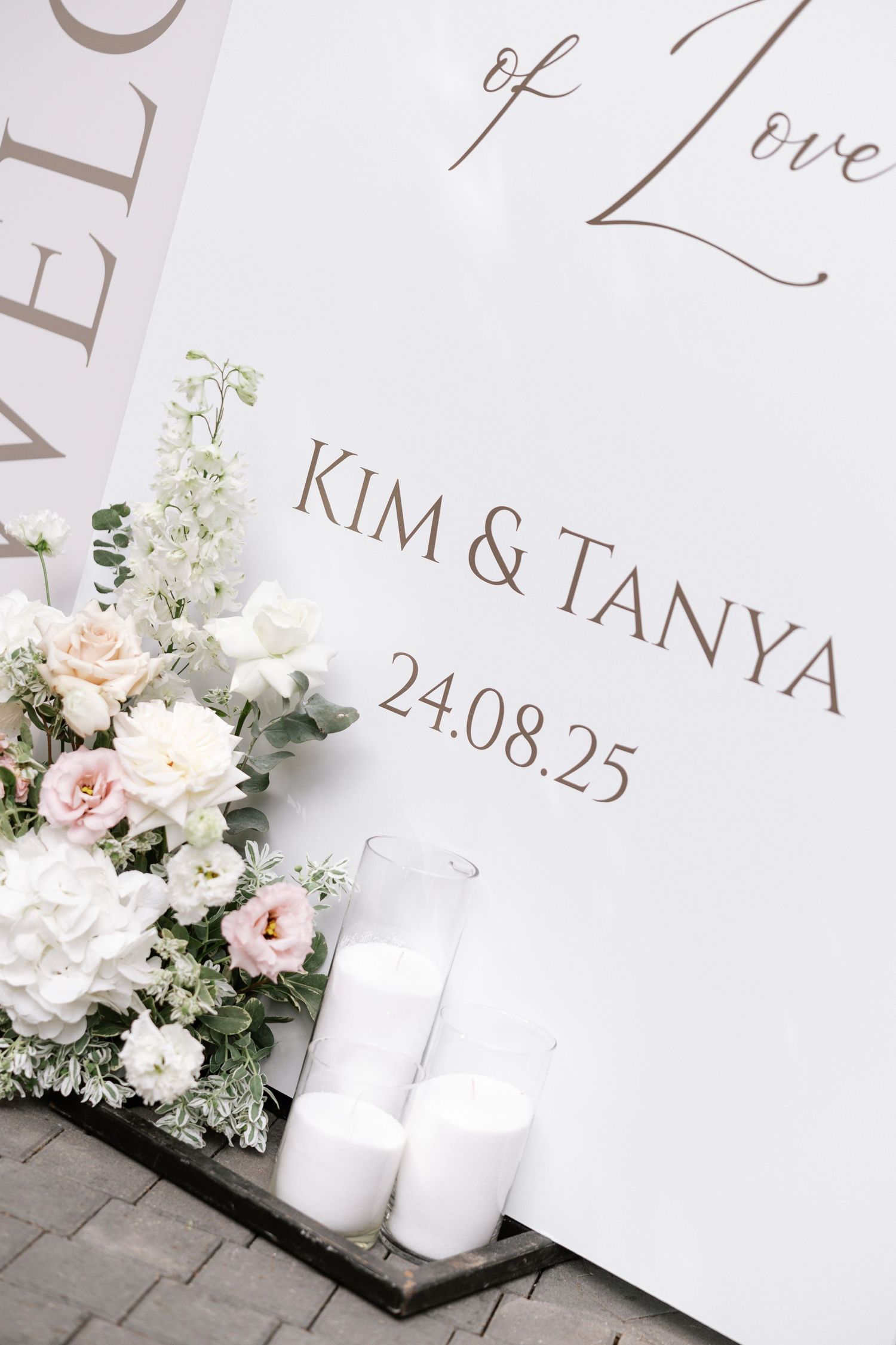 Elegant wedding invitation with pink roses and white candles on display.