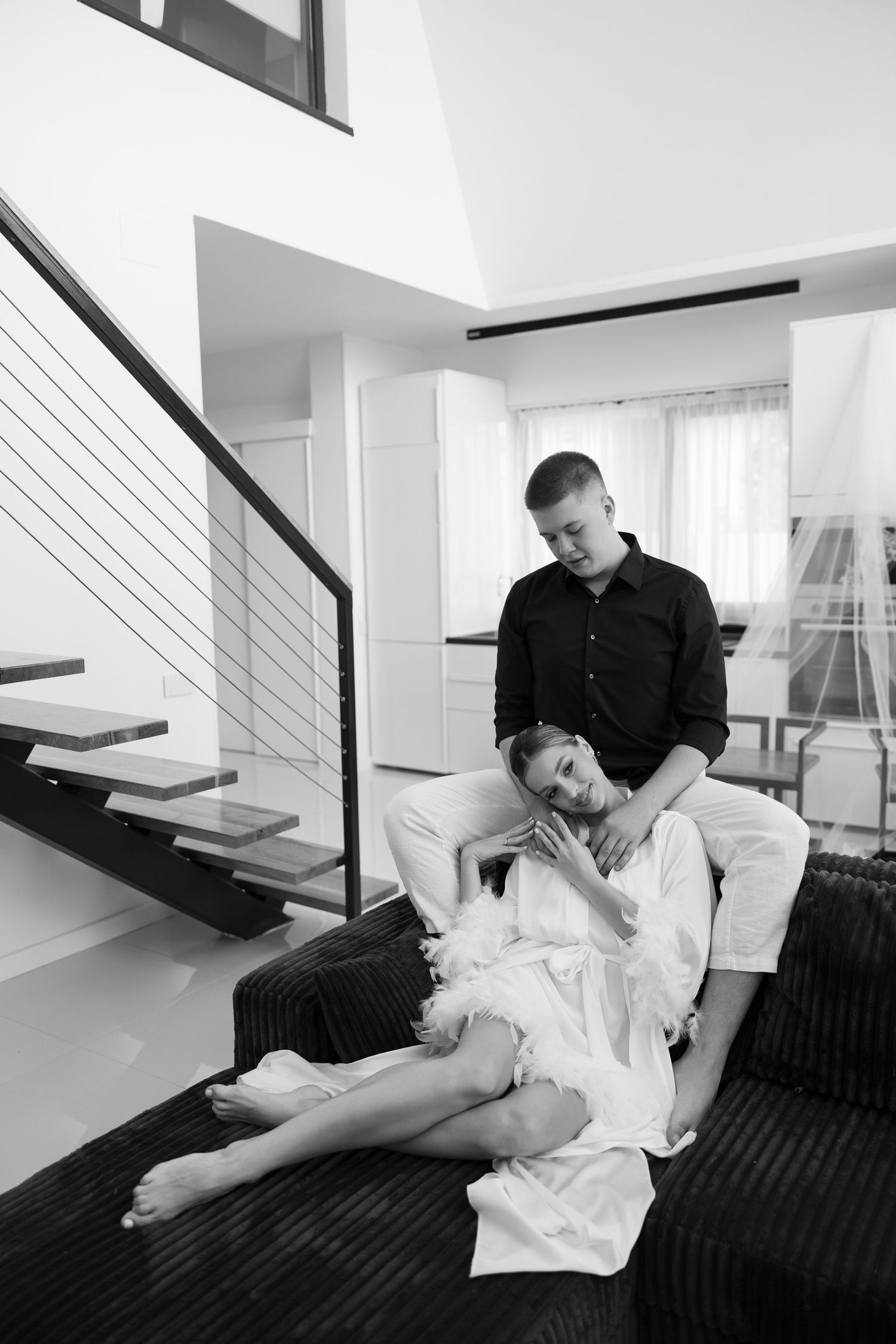 Interior scene with floating wooden stairs and black railings in a contemporary white space.
