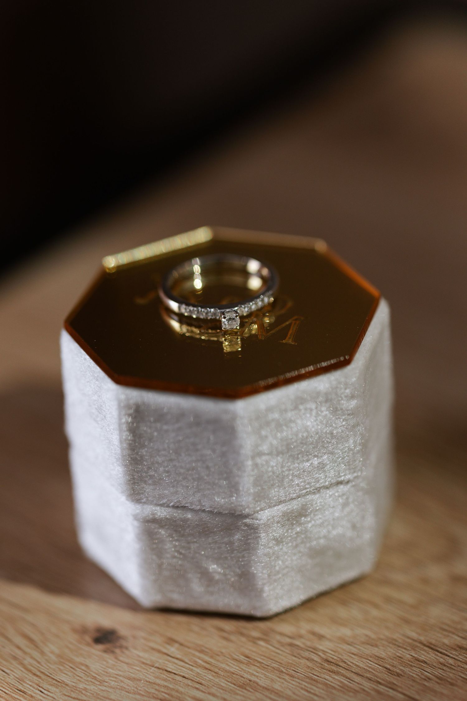 Close-up shot of an elegant diamond engagement ring resting in a white hexagonal ring box.