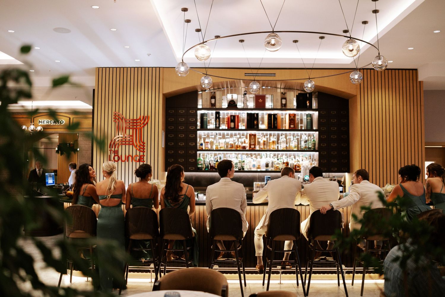 Modern bar setup with wooden panels and ambient lighting at wedding reception.