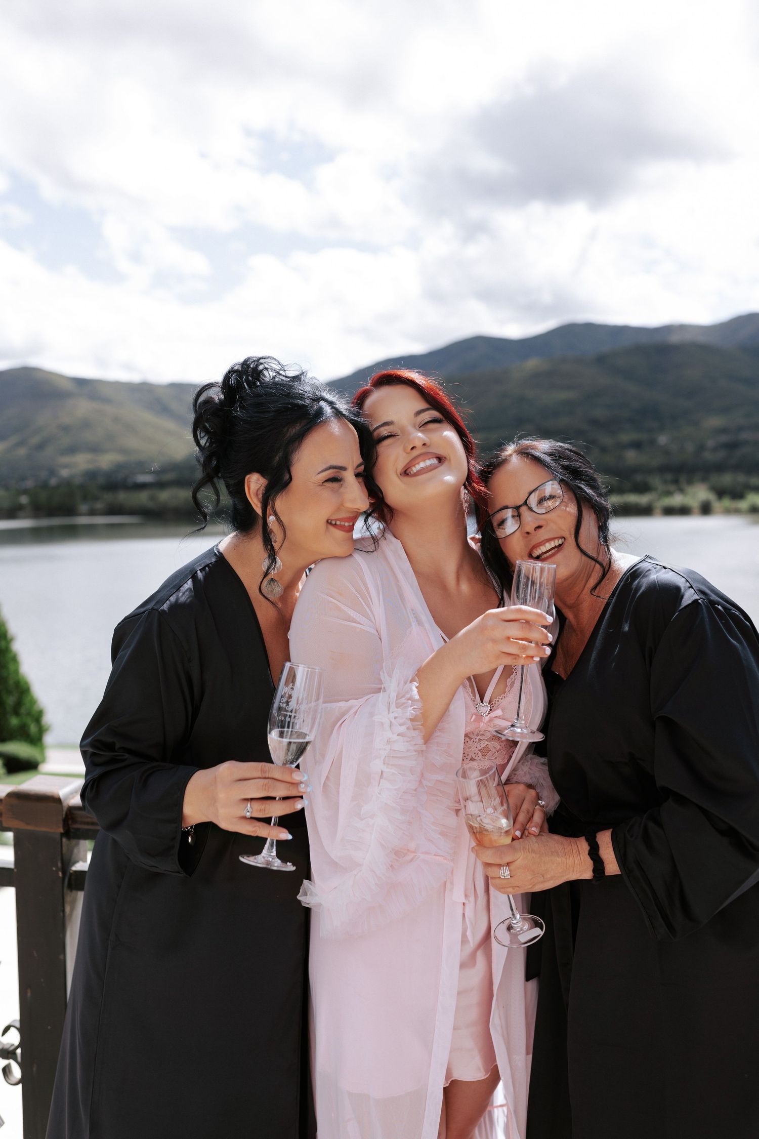 Bridal party laughing together on balcony overlooking scenic mountain landscape. Wedding photographer Bulgaria