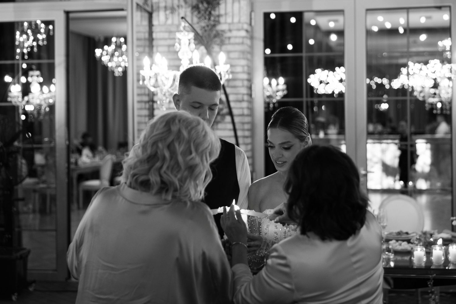 Black and white photo of guests gathered at an evening wedding reception.