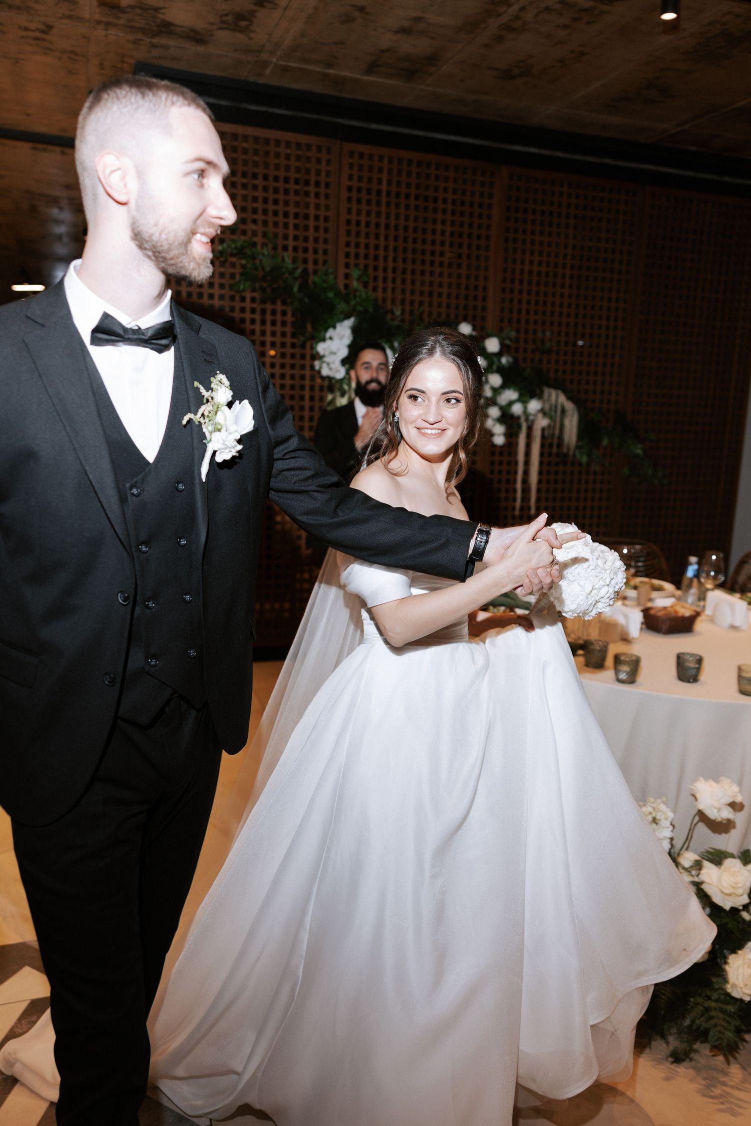 A joyful moment captured at a wedding reception as a couple dances together in formal attire.