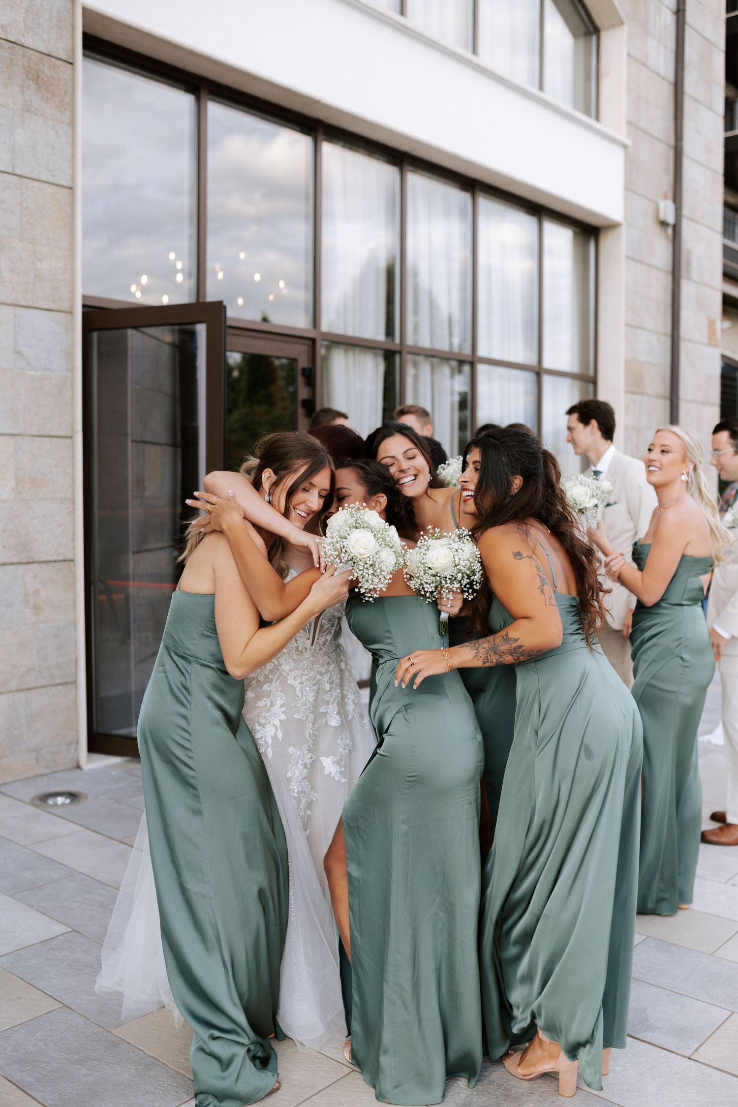 Wedding party shares emotional group hug in sage green bridesmaid dresses Wedding photographer Bulgaria