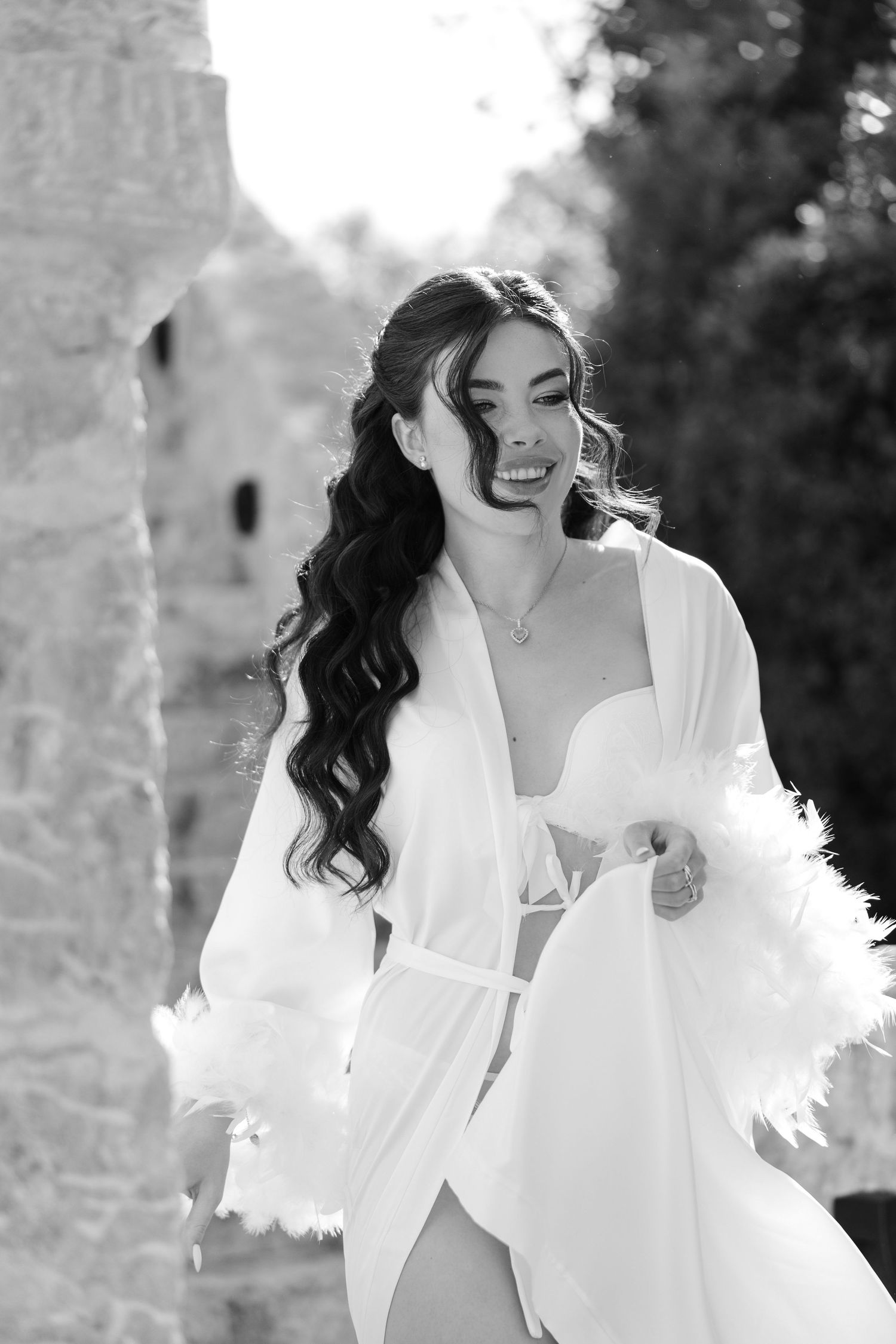 Black and white photo series showing a person in a white blazer posing elegantly against a blurred outdoor background.