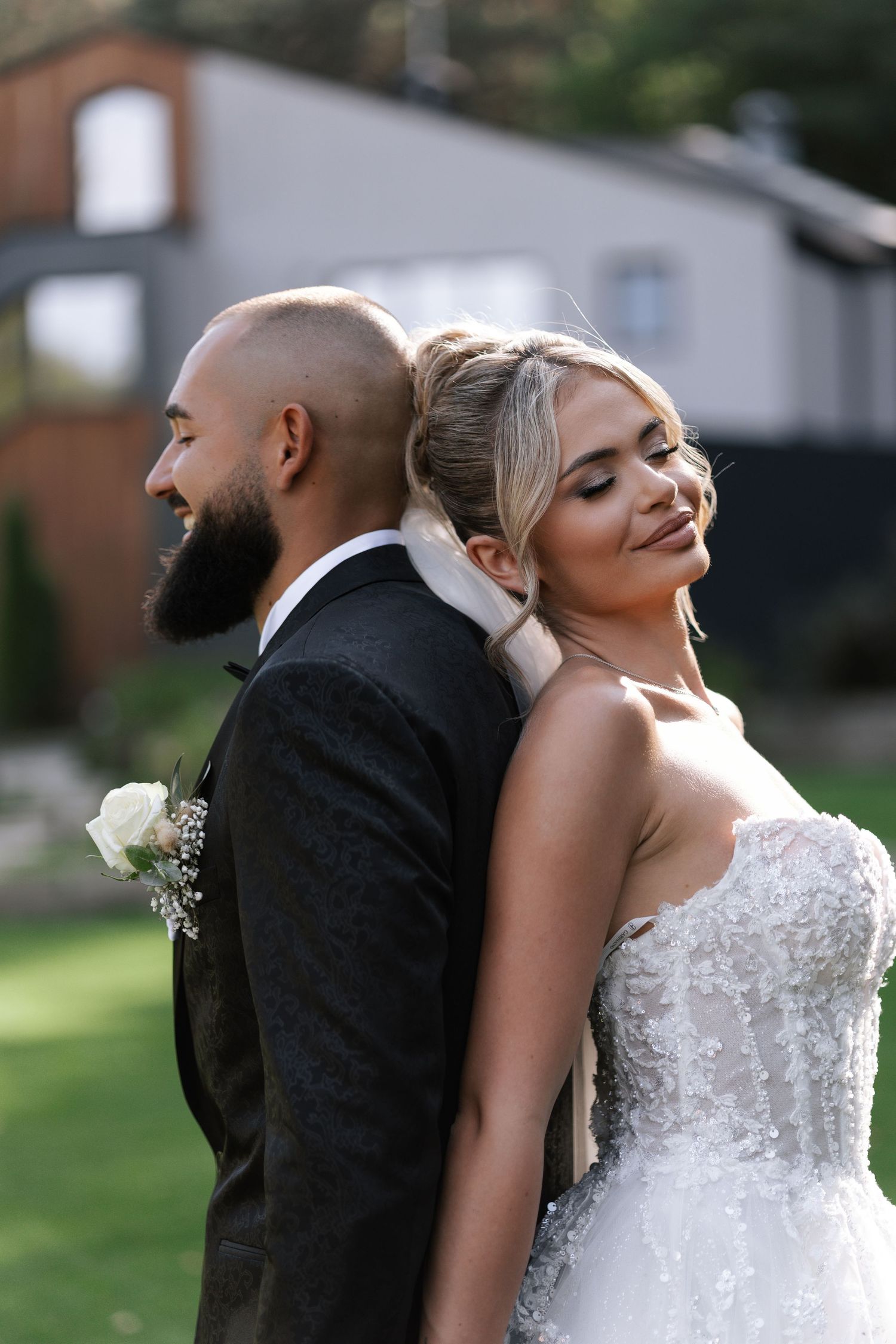 A romantic wedding photo series showing a couple in formal attire posing back-to-back outdoors.