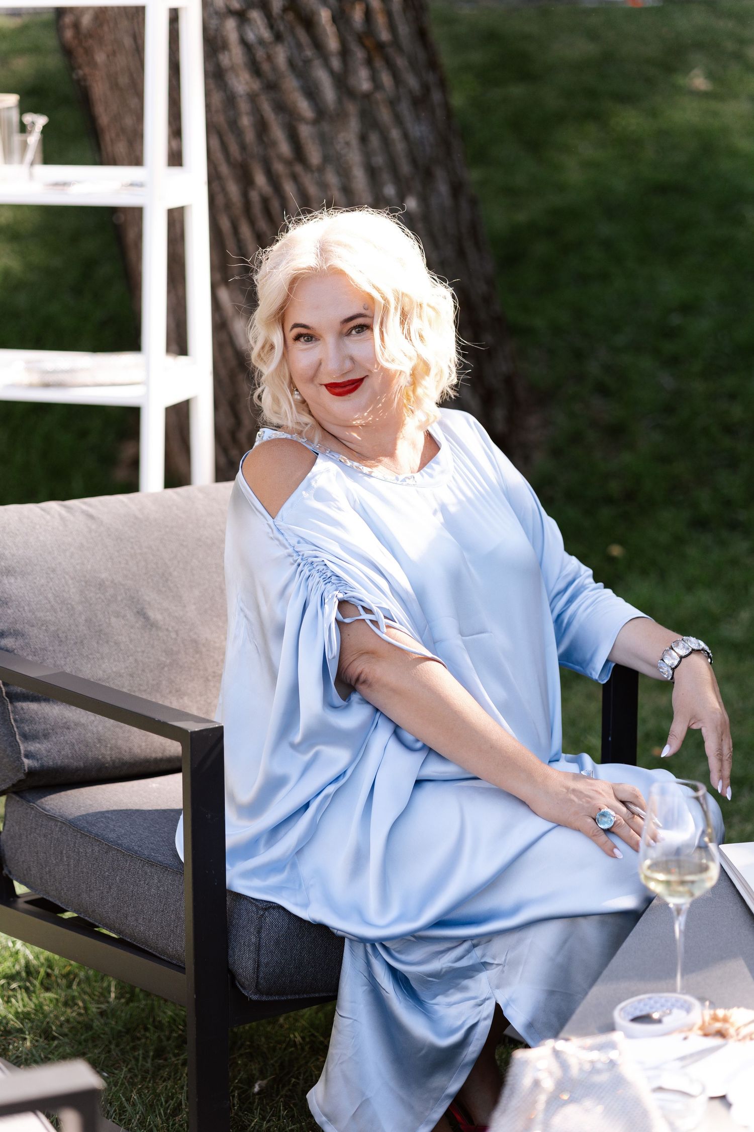 Outdoor seating area with person in light blue clothing relaxing on bench.