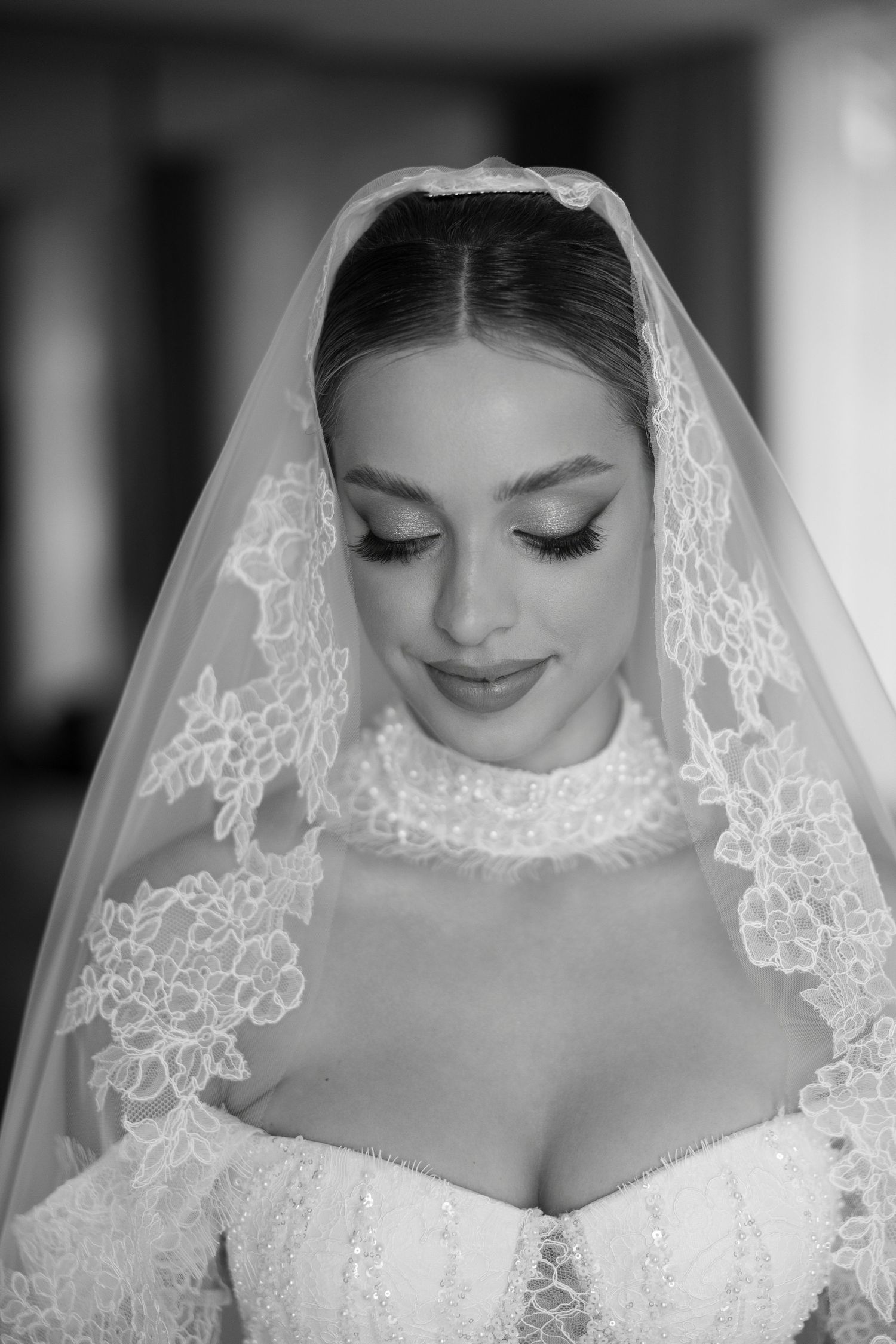 Classic black and white bridal portrait showcasing delicate lace veil and elegant makeup.