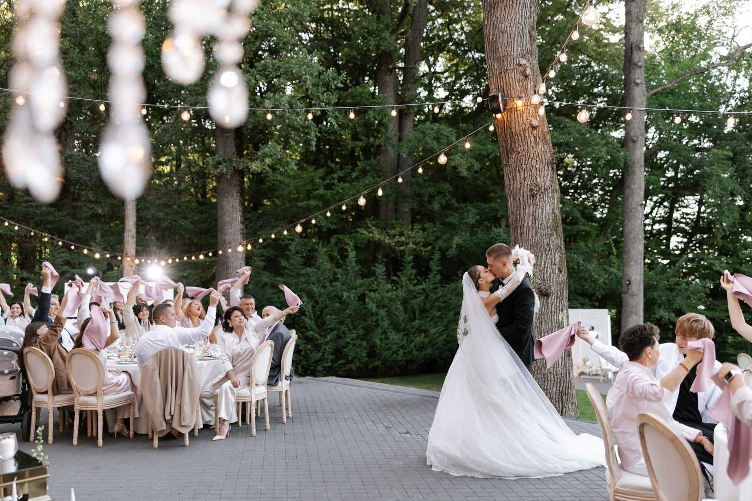 Outdoor wedding reception space with string lights and trees creating a romantic atmosphere.