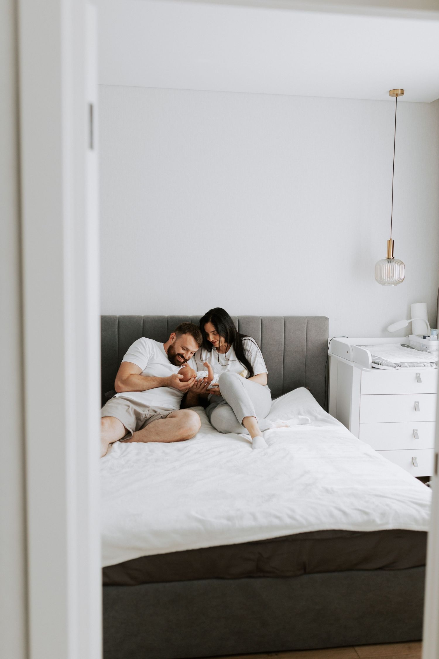 A candid bedroom scene of a family sharing tender moments together.