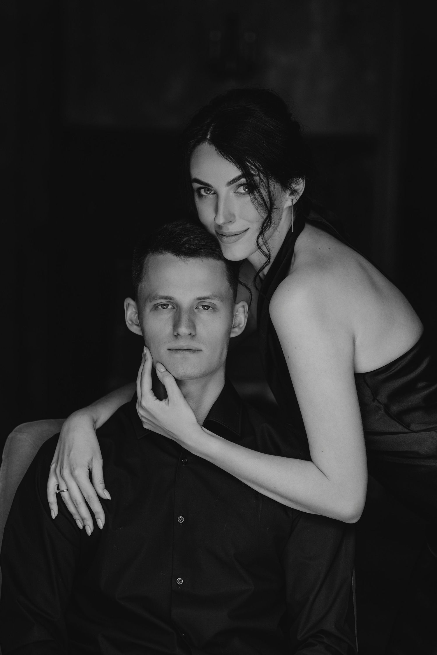Intimate black and white portrait of a couple in formal attire.