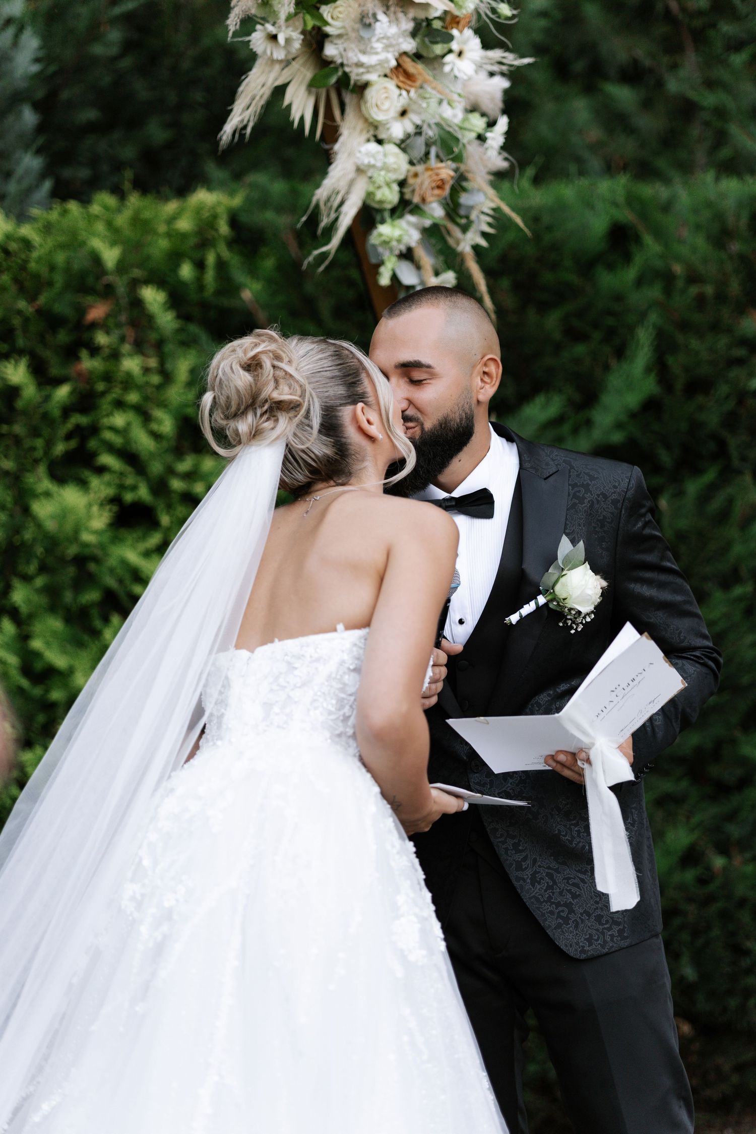 A romantic wedding ceremony sequence showing a couple exchanging vows and sharing an intimate moment outdoors.