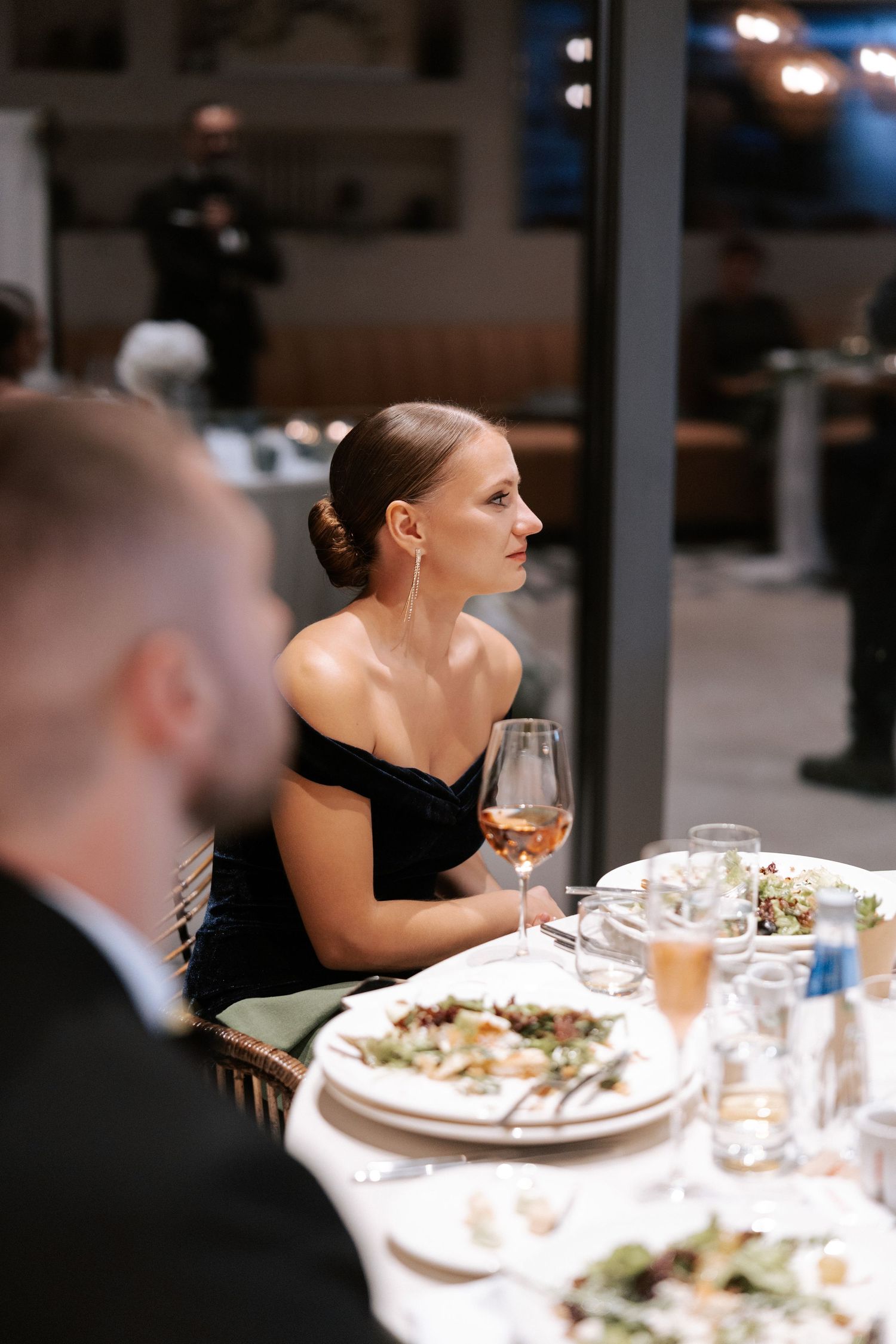 An elegant dinner setting at a wedding reception with formal place settings and wine glasses.