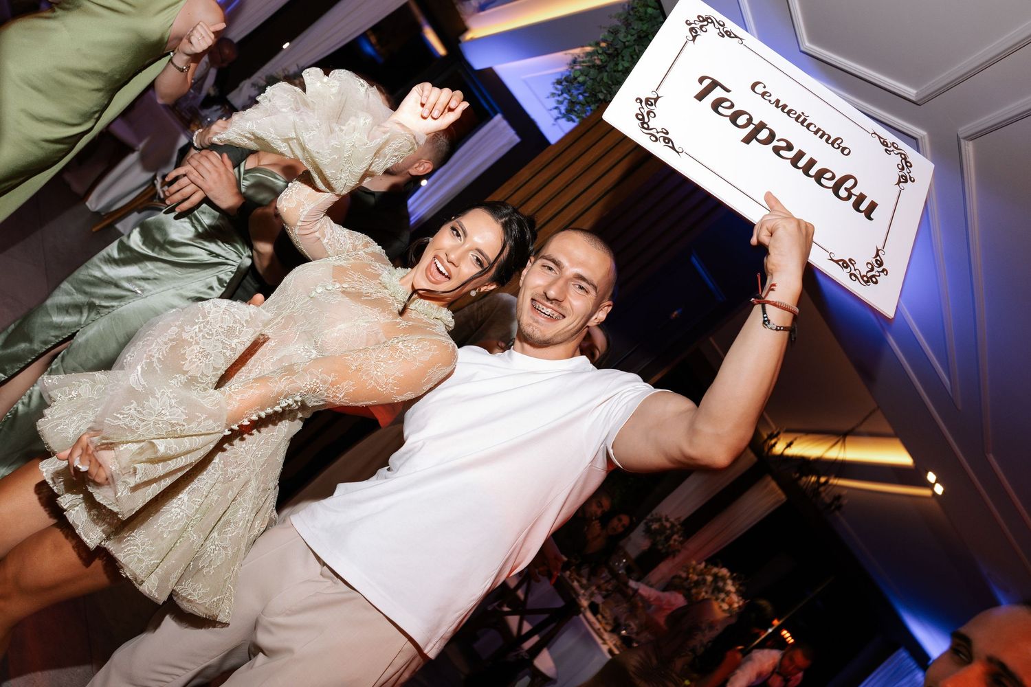 Guests dancing and celebrating at a lively wedding reception with dynamic lighting and joyful movements.