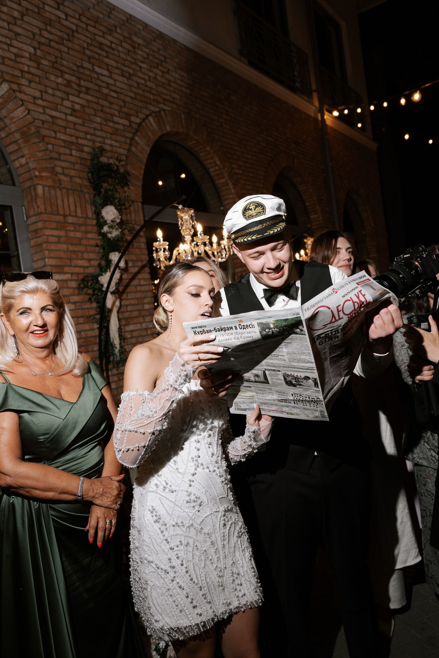 Wedding celebration at night with guests dancing and celebrating in a brick-walled venue.