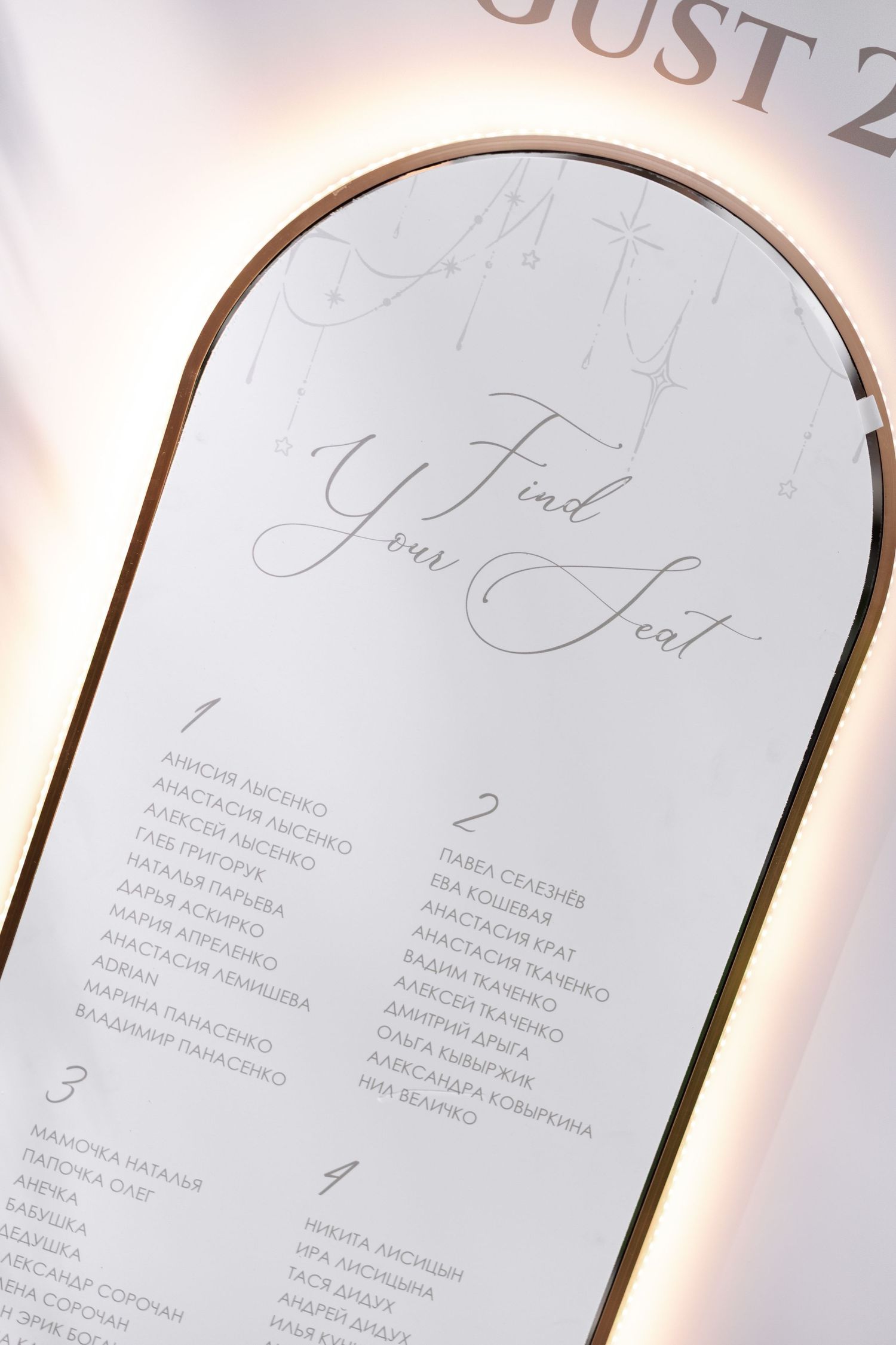 Elegant wedding seating chart displayed on curved white panels with calligraphy text.