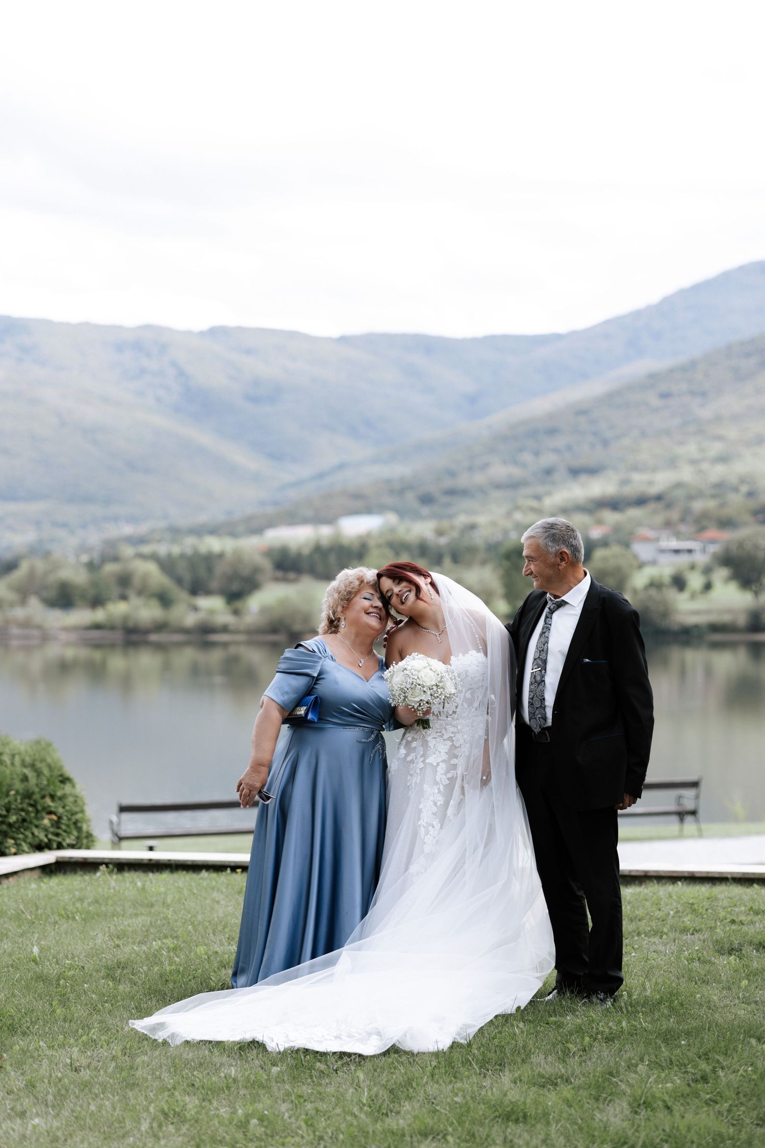 A heartwarming wedding photo with a scenic mountain lake in the background.