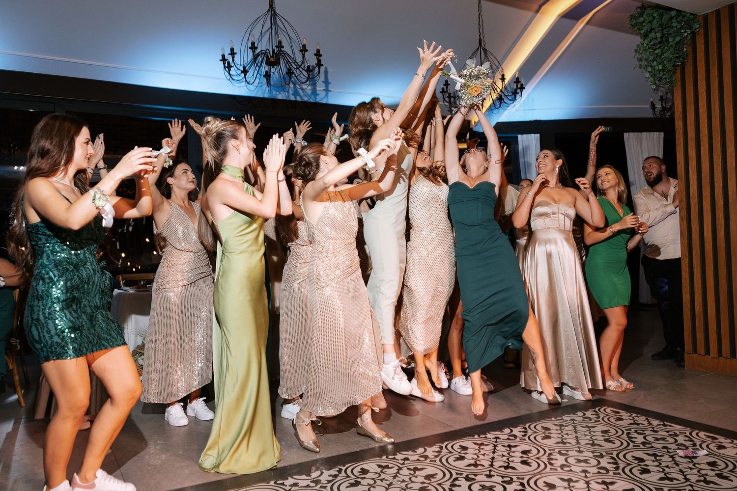 Wedding reception guests dancing together on a patterned dance floor during a celebration.