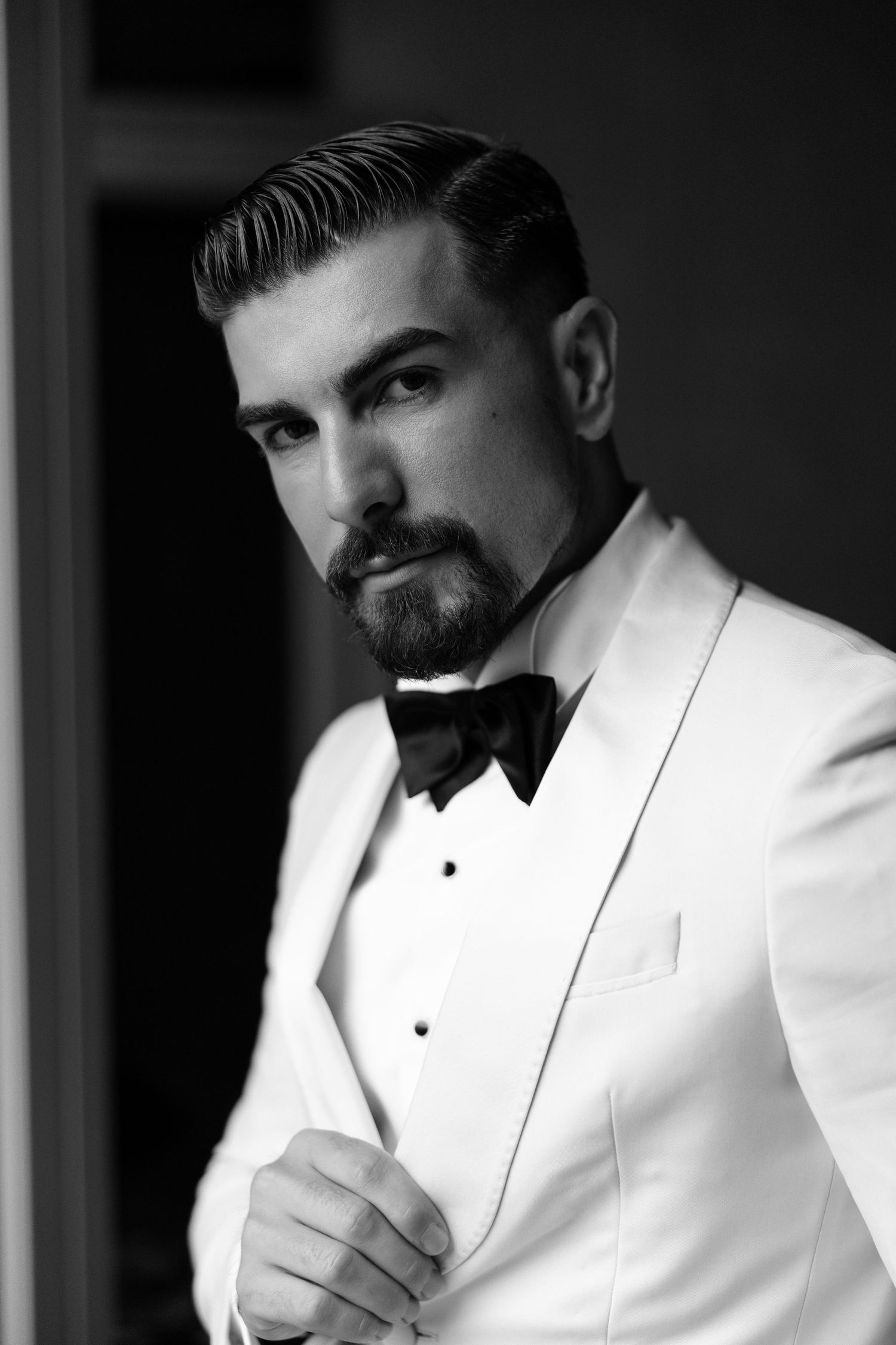 A black and white portrait series of a man in a white tuxedo jacket and black bow tie.