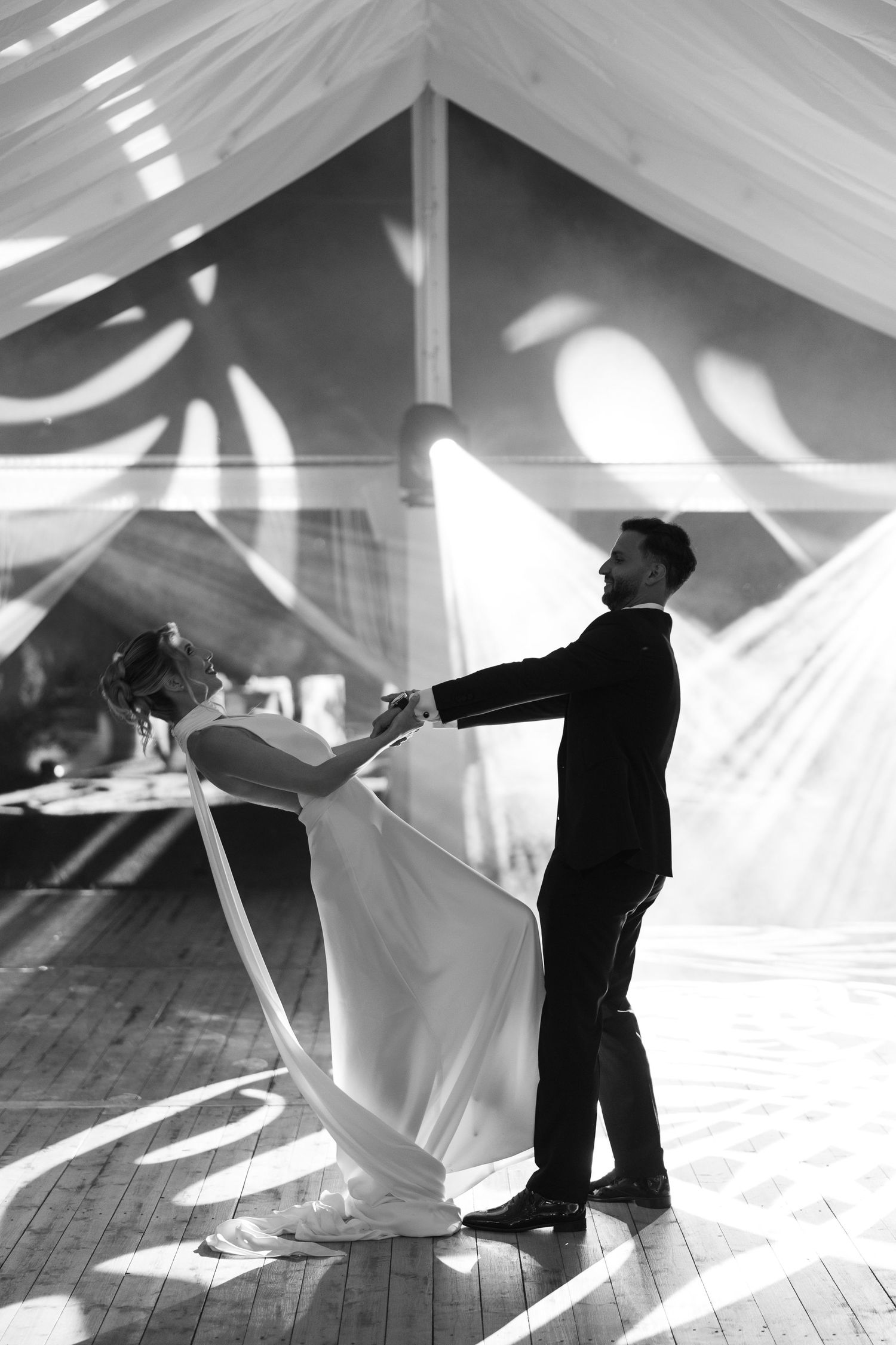 A sequence of black and white photos showing two small figurines dancing together under flowing white fabric.