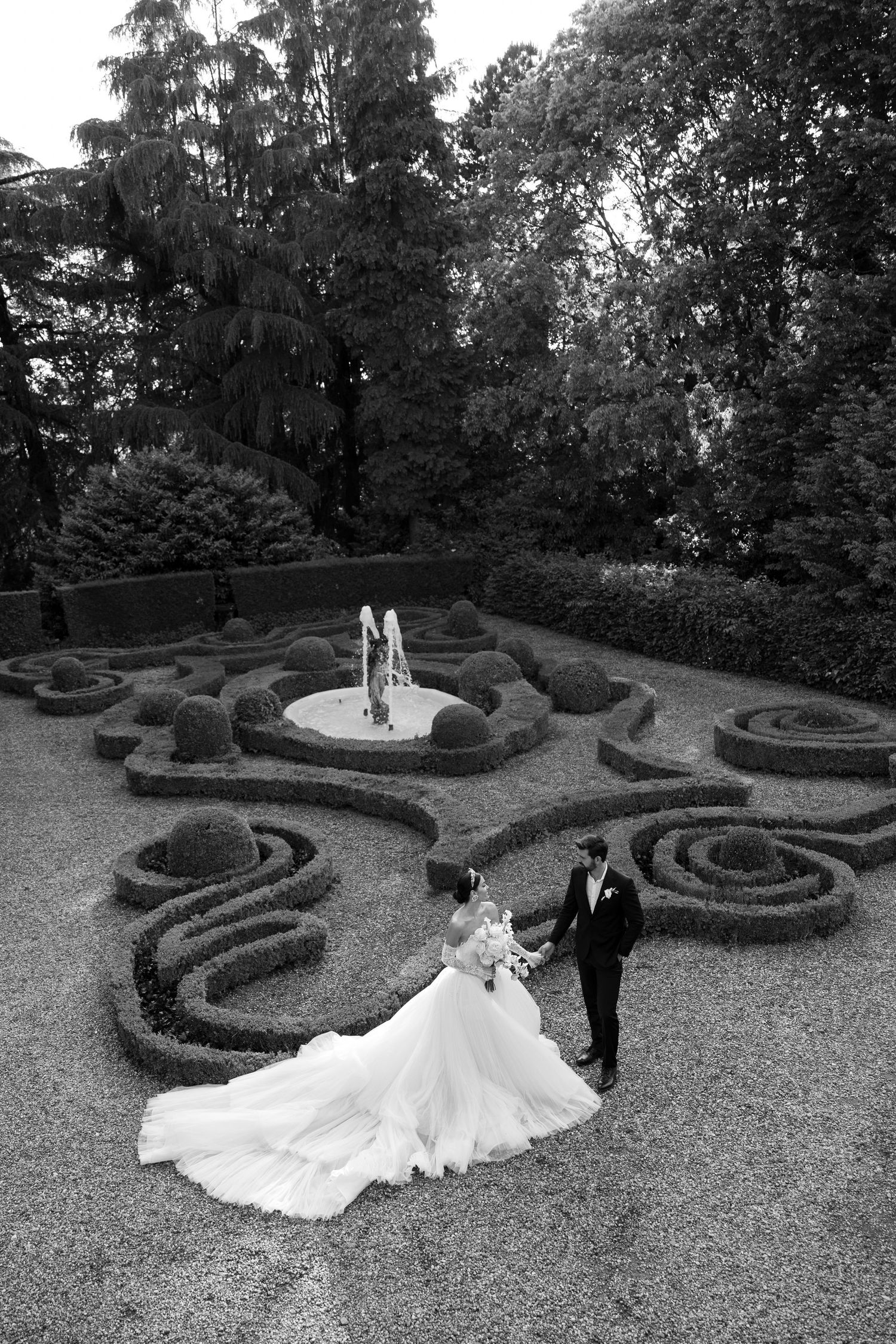 A series of wedding photos showing a couple posing in a formal garden with elegant spiral topiary designs and gravel paths.