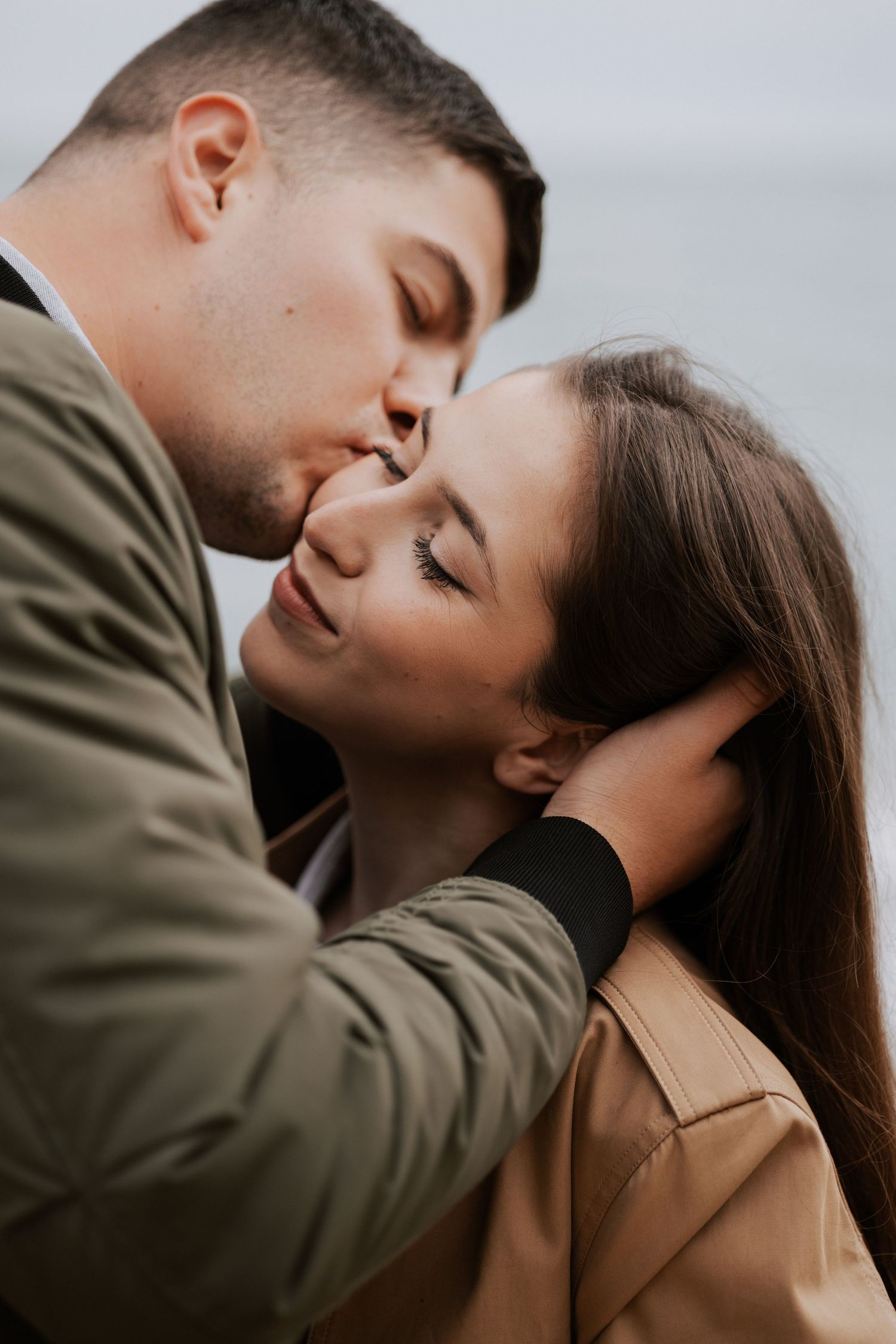 Intimate close-up of a couple sharing a tender kiss outdoors.