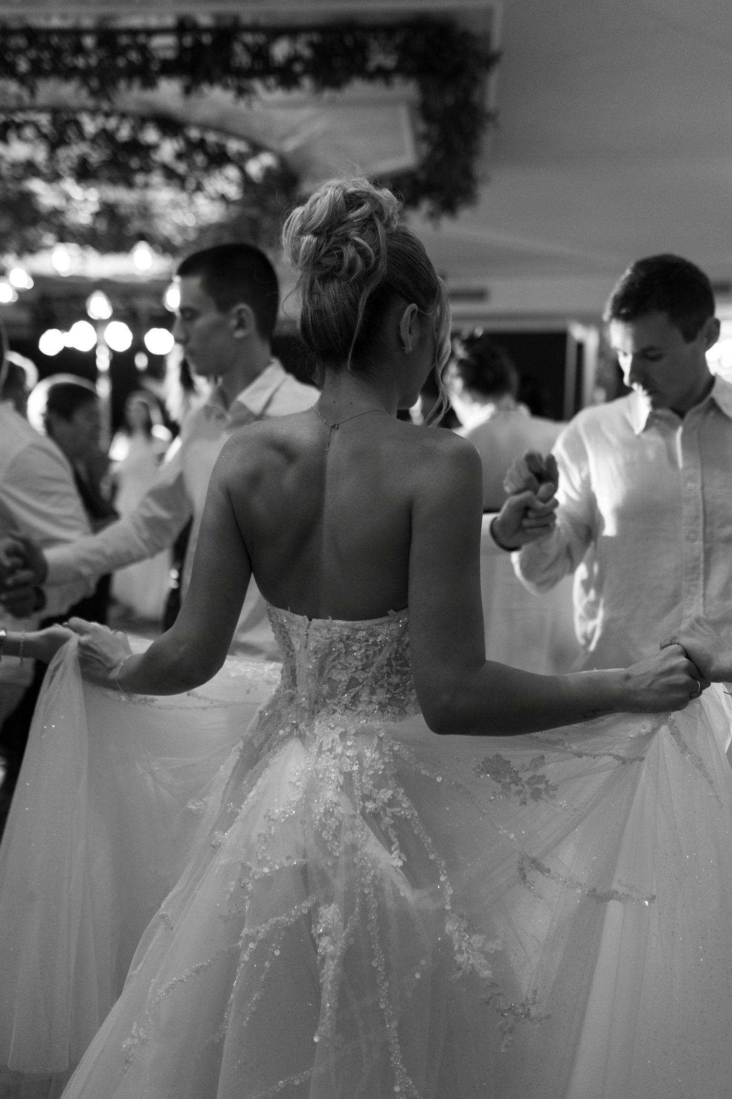 Black and white photo series showing bridesmaids in elegant white dresses at a formal wedding reception.