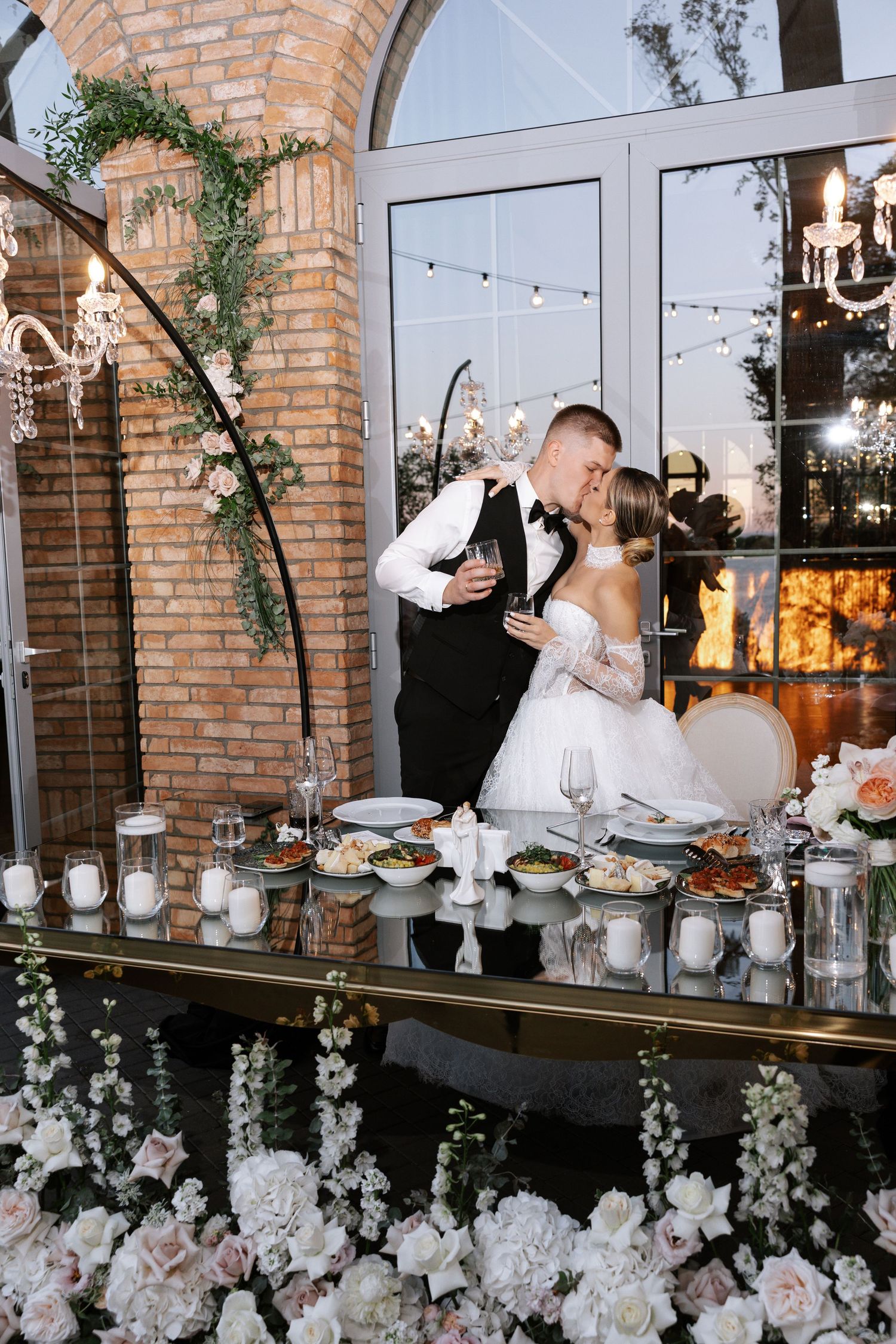 Wedding reception at brick venue decorated with hanging florals and string lights.
