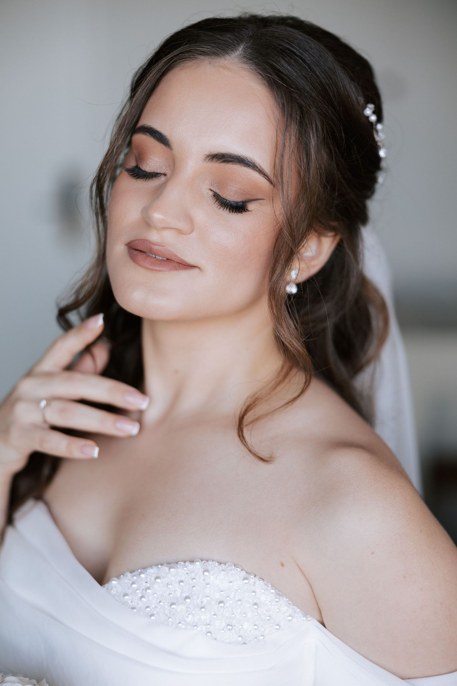 Close-up beauty shot of bridal makeup and hairstyle with soft romantic styling.