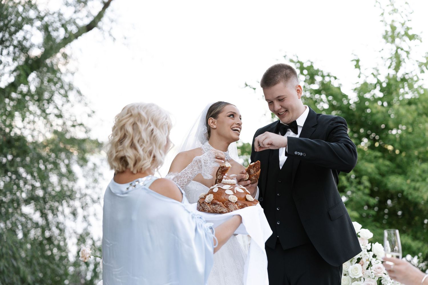 Wedding party enjoying champagne toasts outdoors in a garden setting.