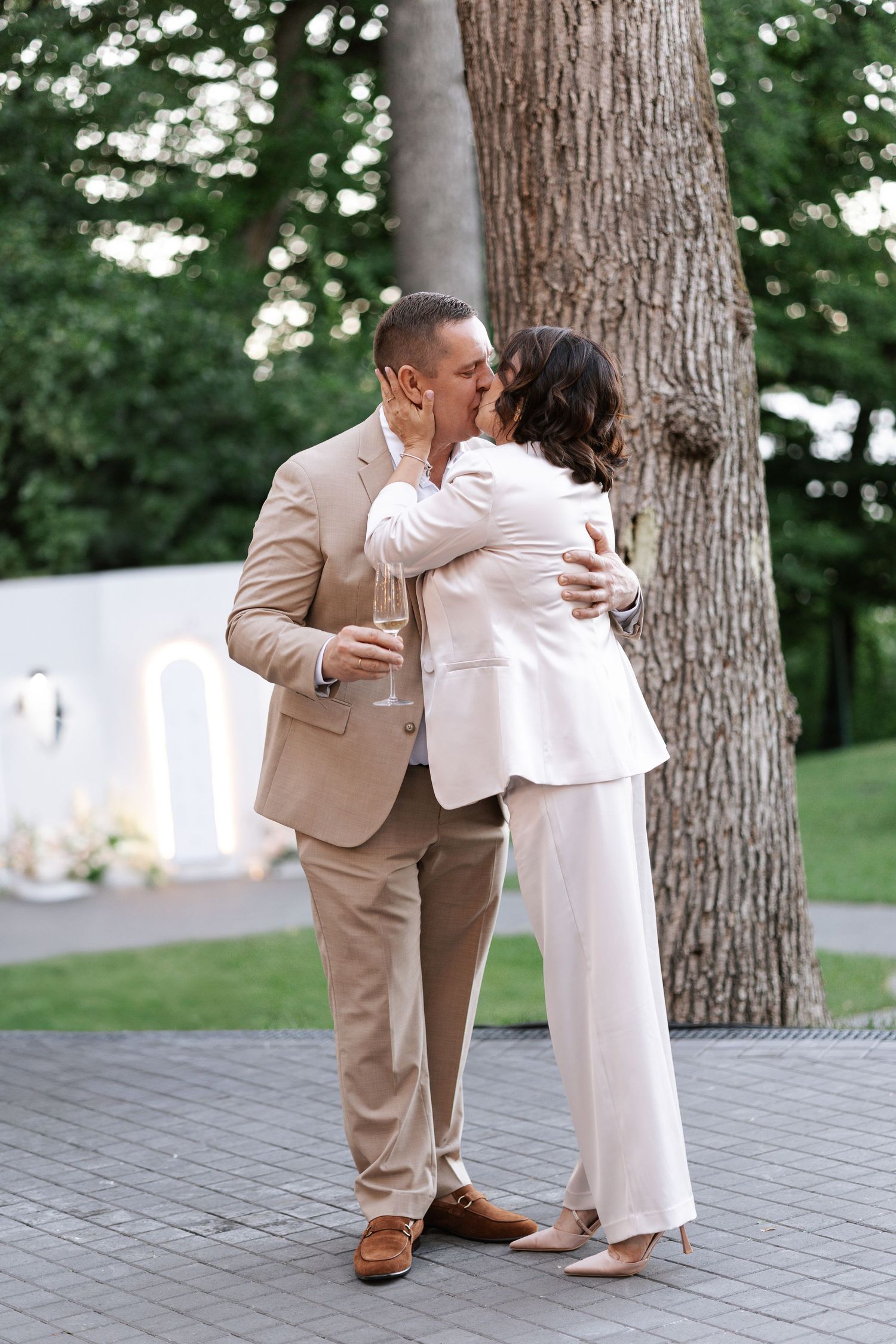 Couple sharing an intimate moment against a tree trunk on their special day.