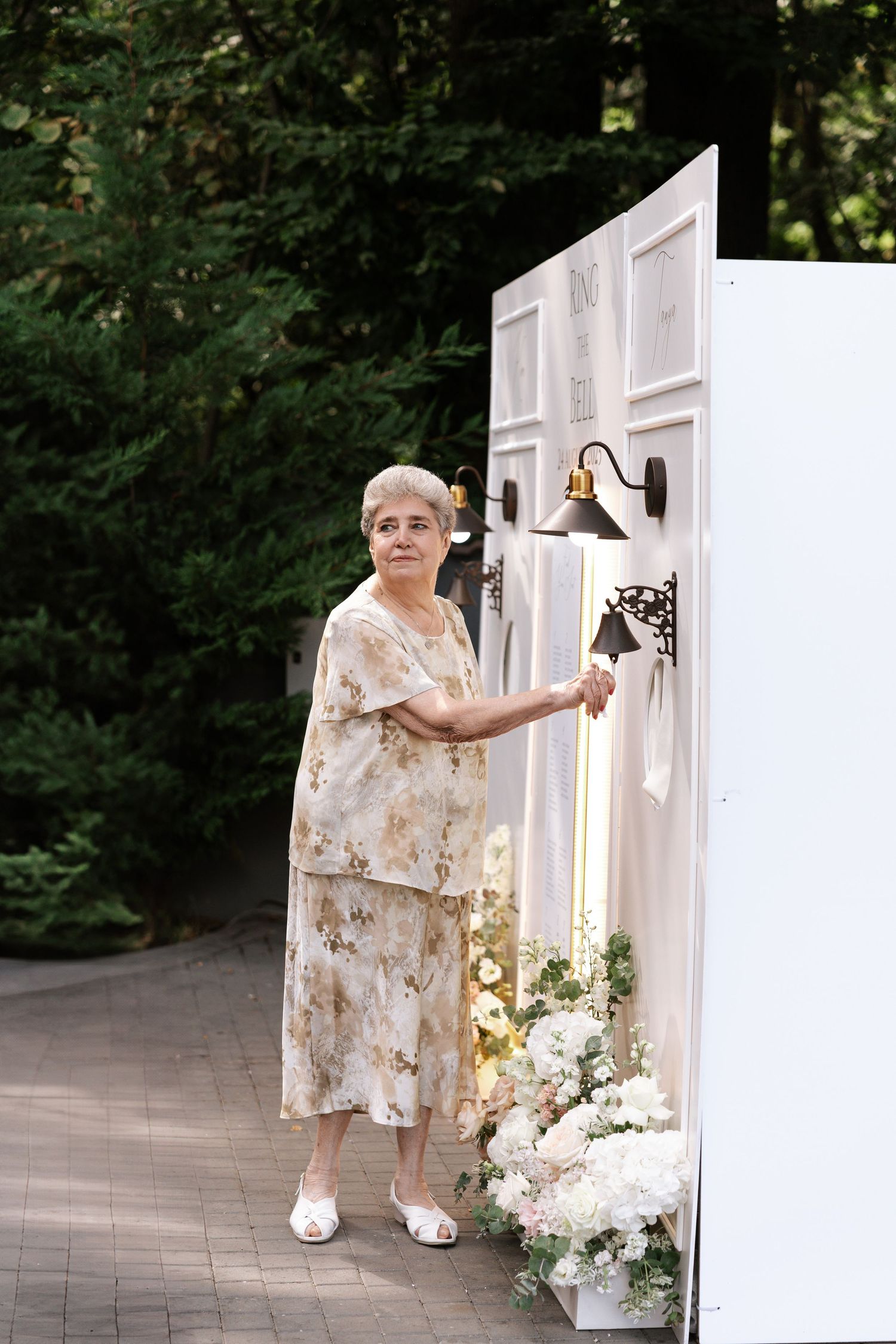 Person in a floral dress arranging decorative elements at an outdoor venue.