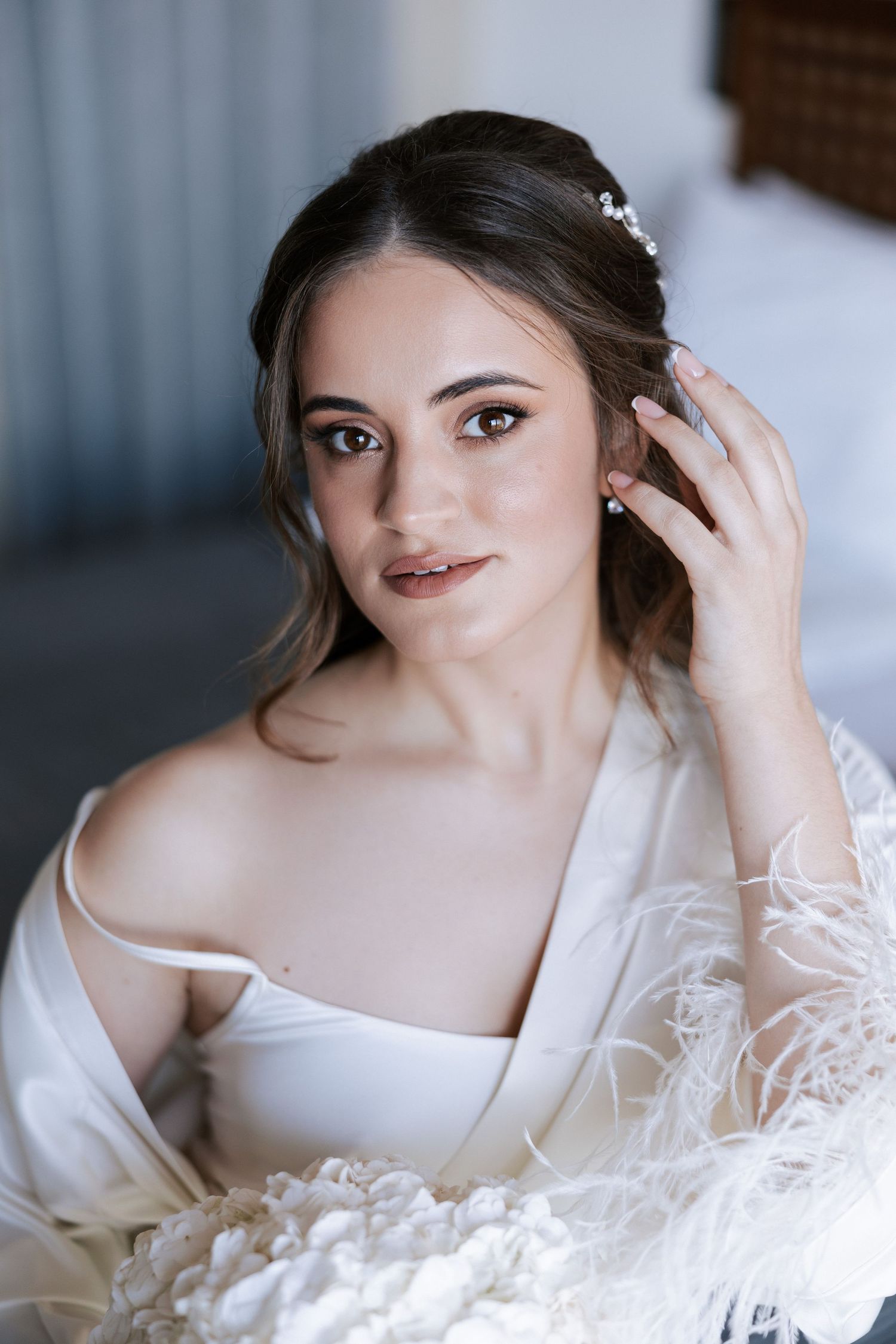 A bride in delicate white lace robe prepares for her wedding day.