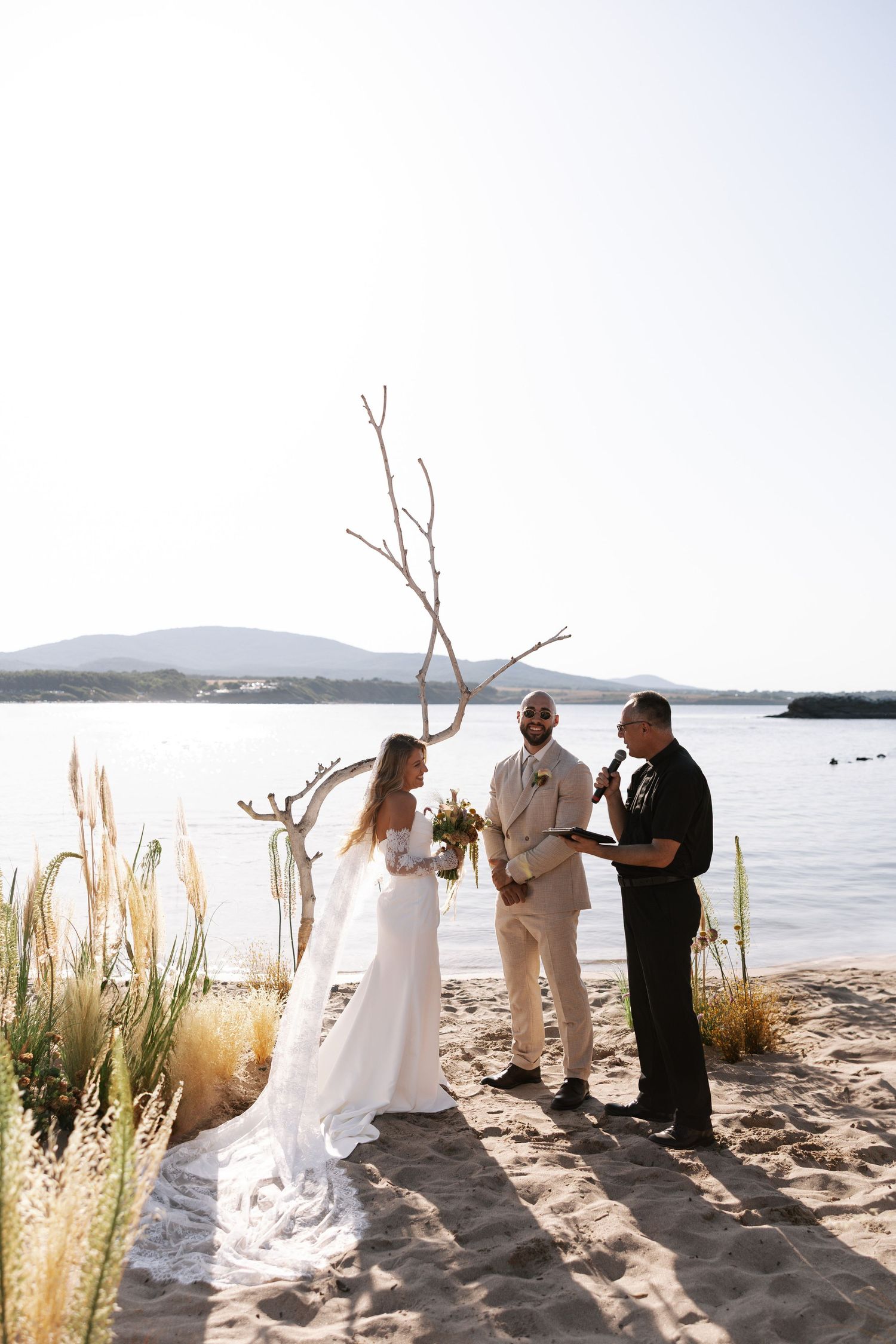 A series of beach wedding ceremony photos with pampas grass decor at sunset by the water.