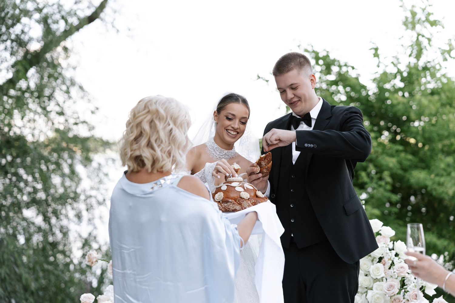 Wedding party celebrating with champagne toasts in an outdoor garden setting.