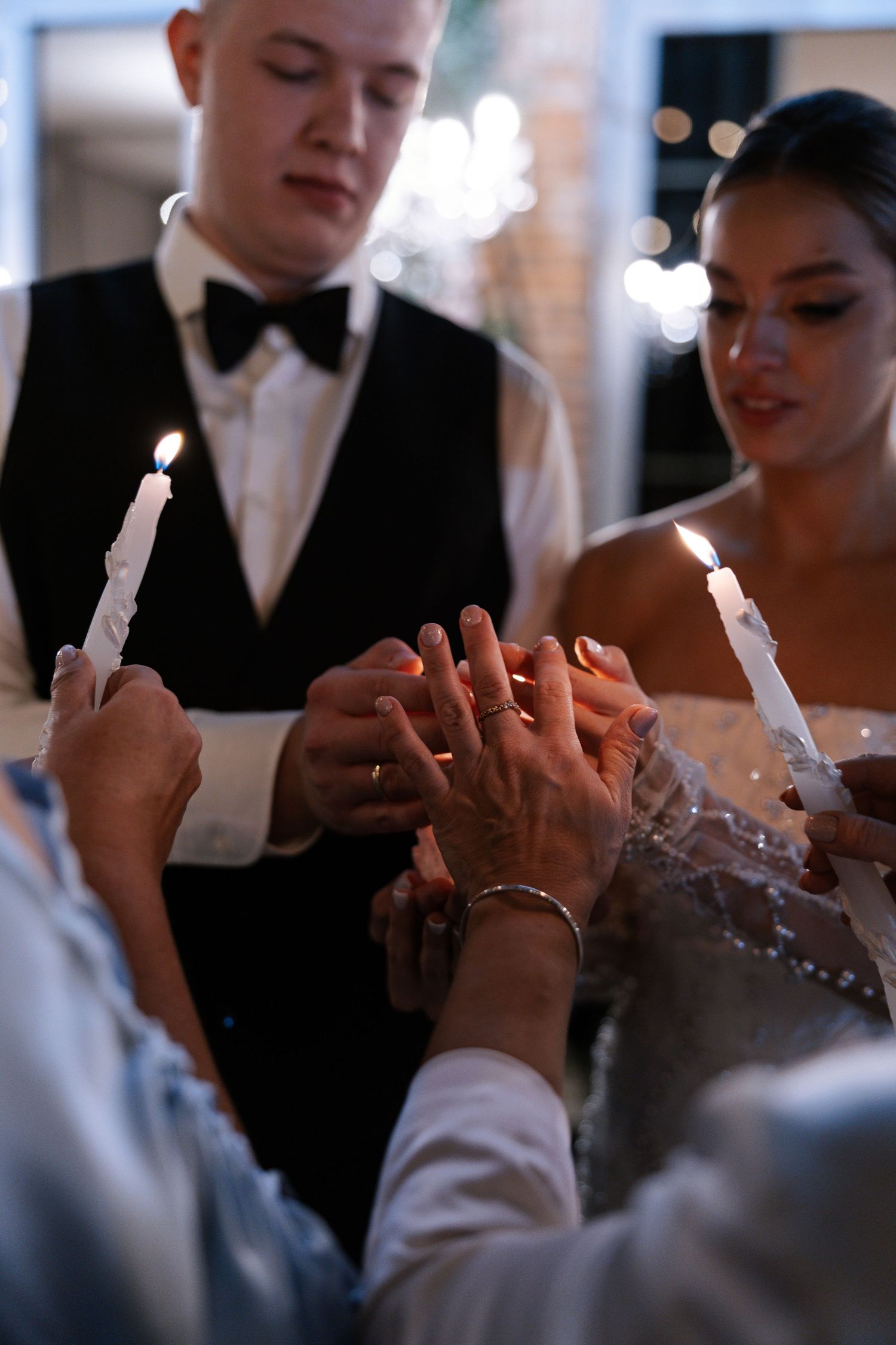 Close-up of hands clapping during a wedding celebration in formal attire.