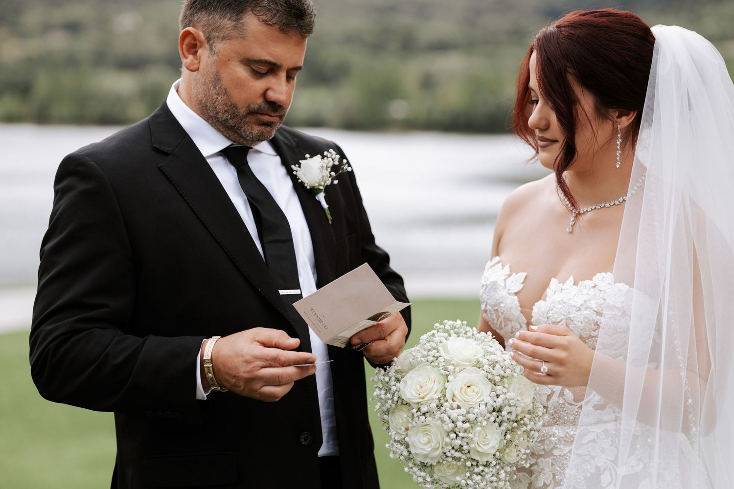 Intimate wedding moment captured outdoors with mountain scenery.