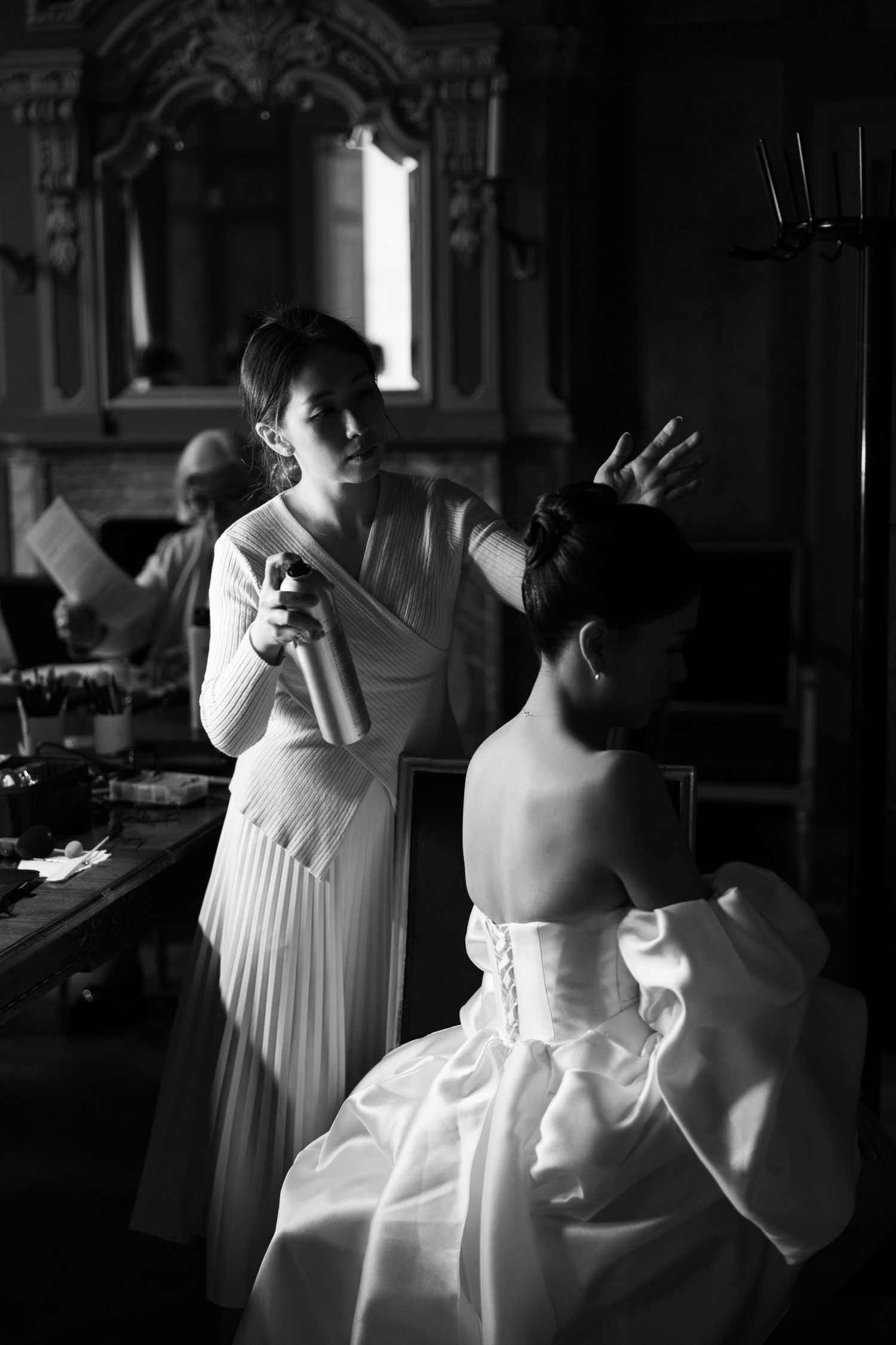 A series of black and white photographs showing intimate moments during a wedding preparation in moody lighting.