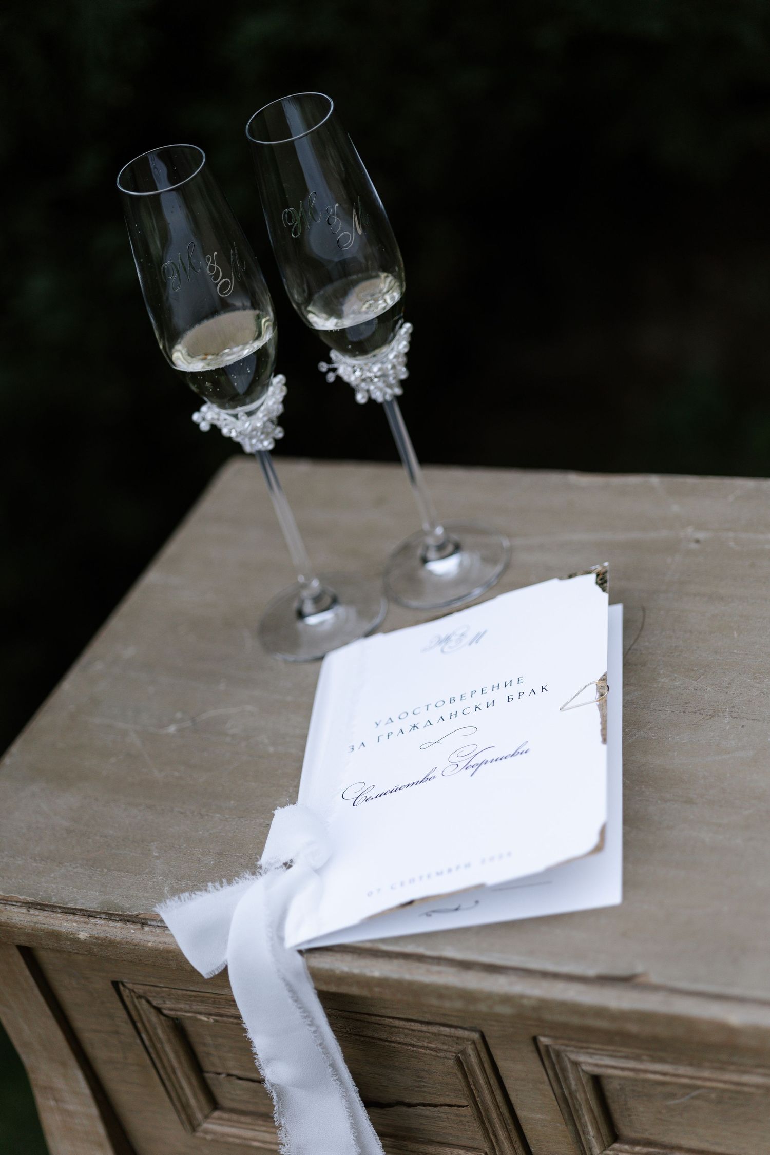 Two elegant wine glasses with decorative white details rest on a rustic wooden surface in a sequence of similar shots.