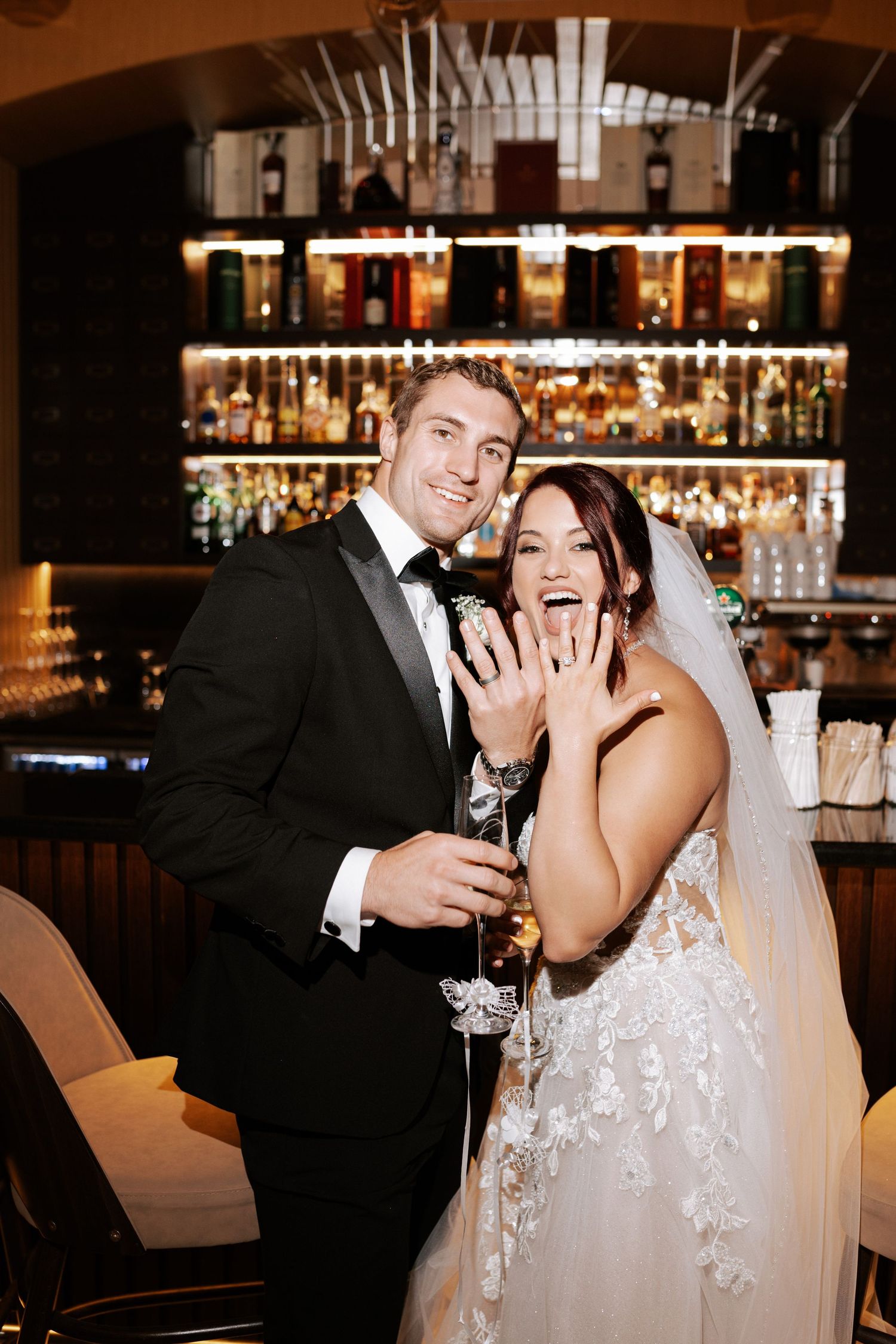 Celebratory moment at wedding reception bar with champagne.