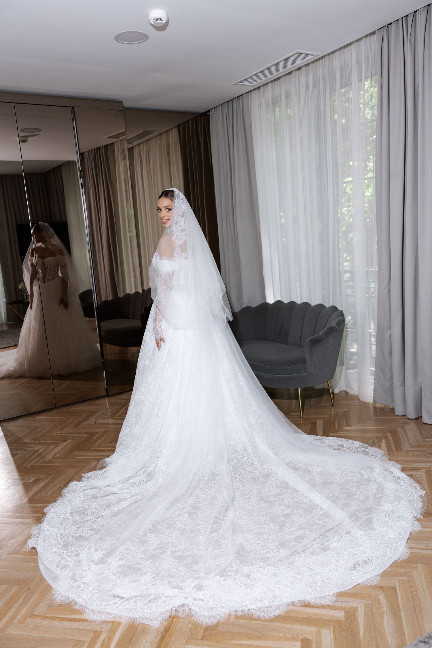 Dramatic full-length shots of a wedding dress with cathedral train in a light-filled room.