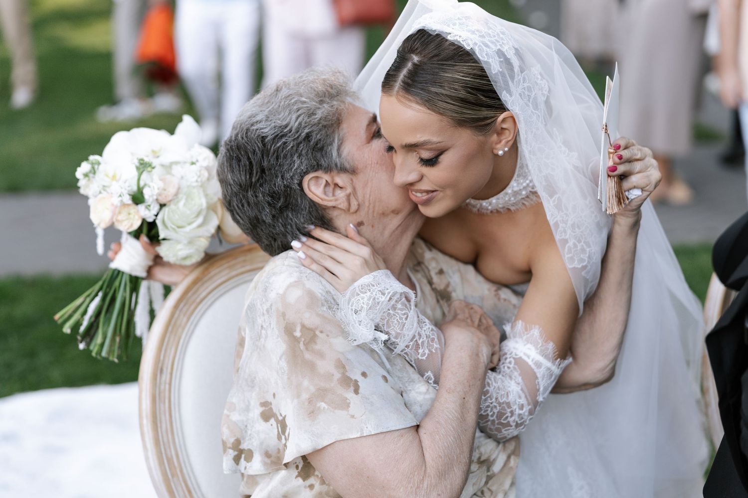 Romantic wedding couple sharing intimate kisses in outdoor garden setting with elegant decor.
