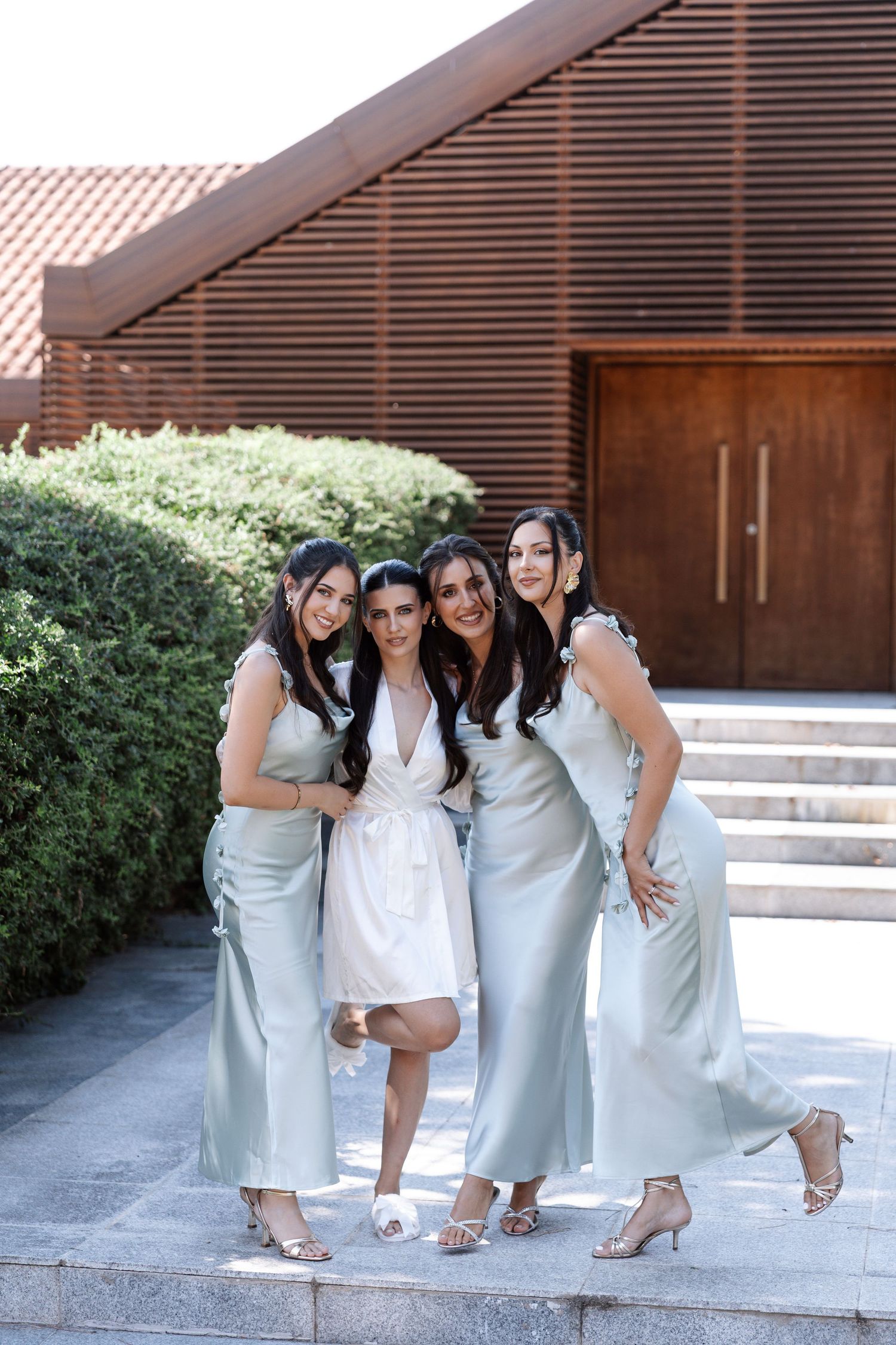 A group of bridesmaids in pale blue dresses pose together on outdoor steps in a candid photo sequence.
