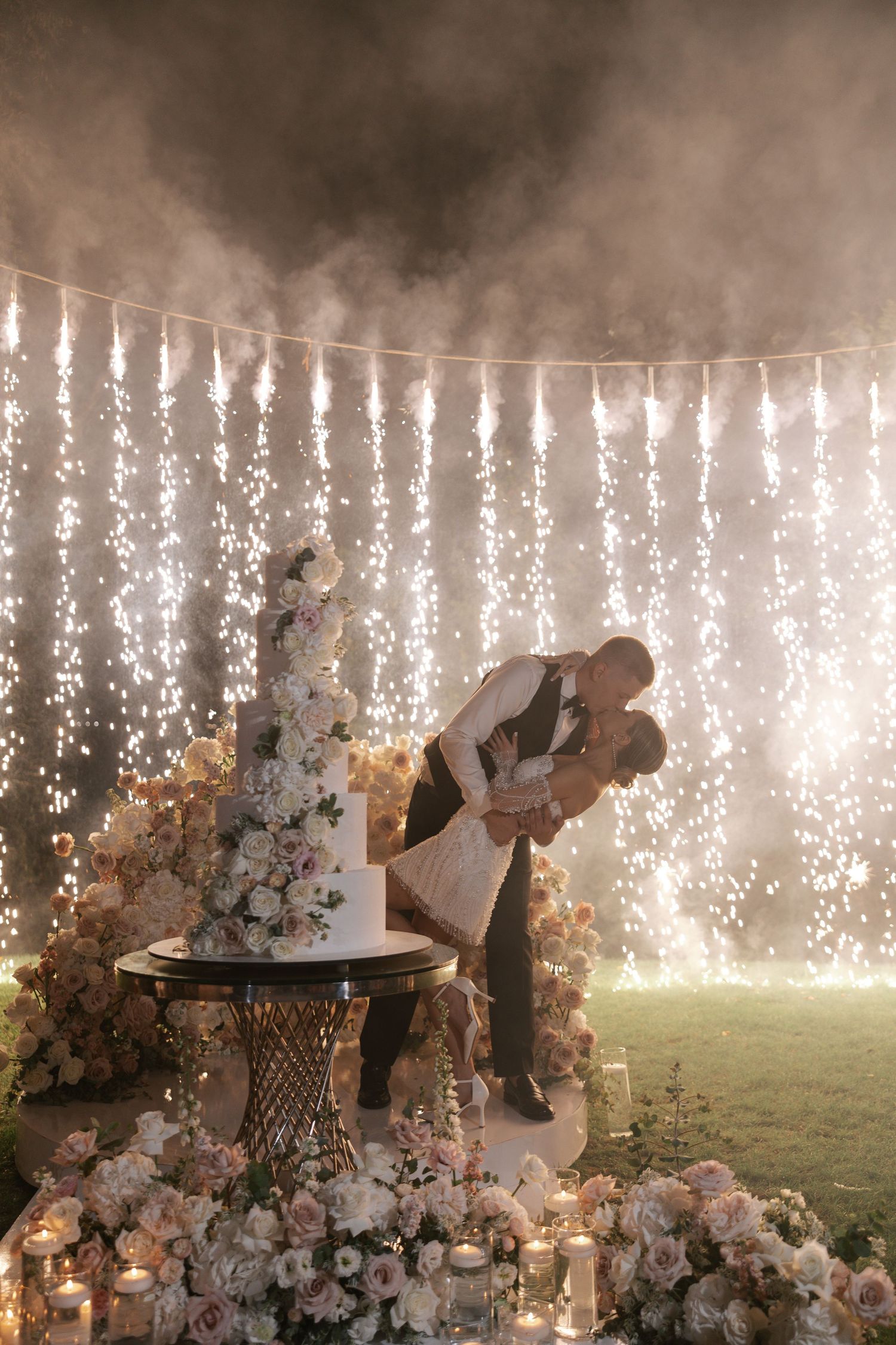 Wedding reception finale with cascading sparkler wall and floral decorations.